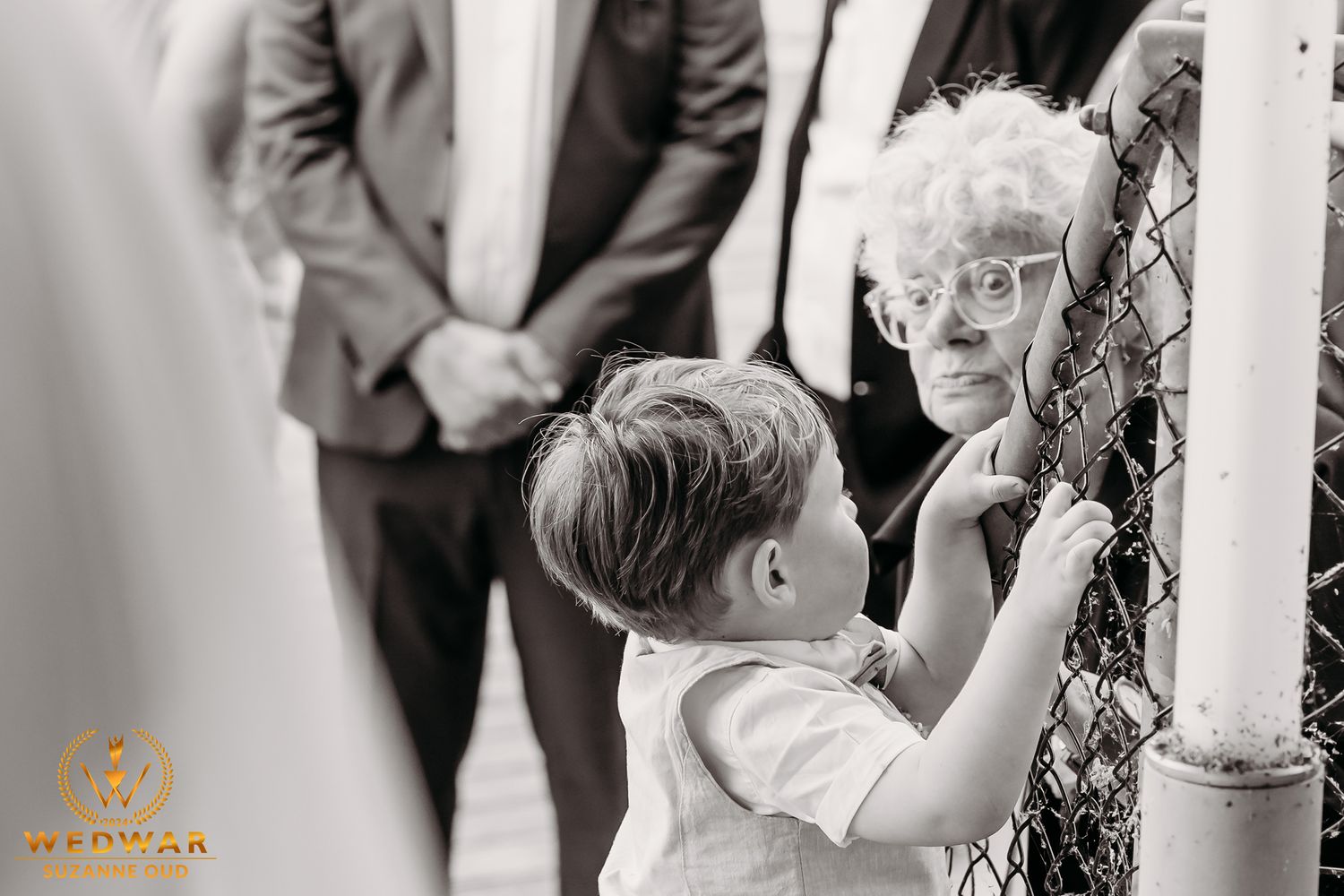 Sweet candid moment at wedding ceremony with vintage black and white photography.
