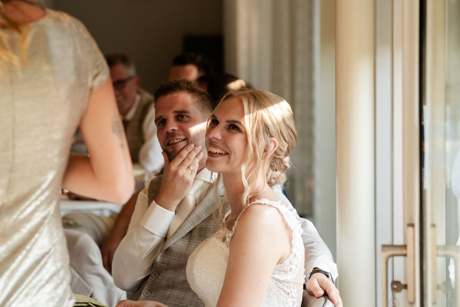 A happy couple shares a tender moment and laughter together during their wedding reception.