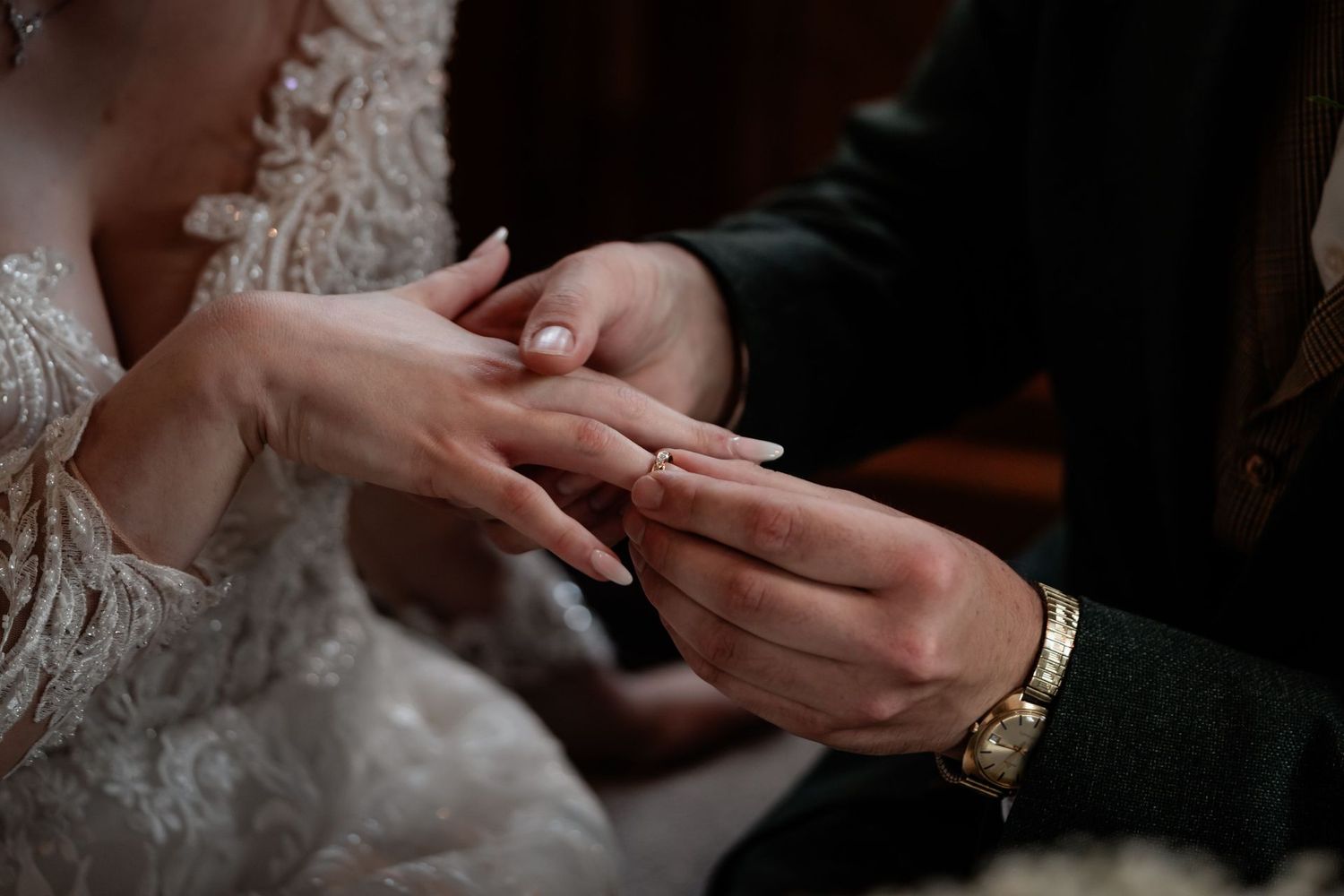 Close-up shot of hands exchanging wedding rings during a romantic ceremony.
