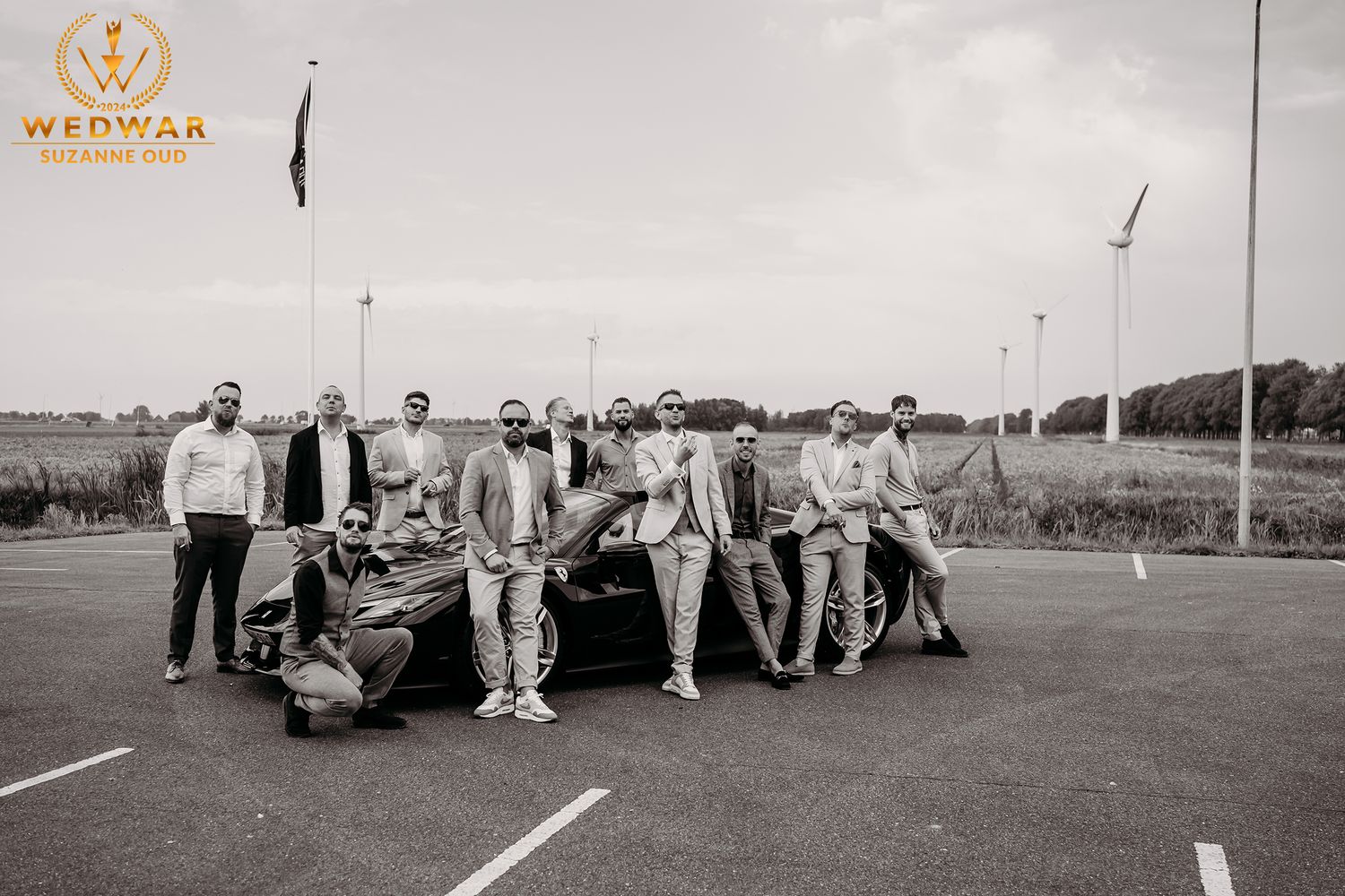 Black and white panoramic sequence showing a wedding party posing outdoors on a sunny day.