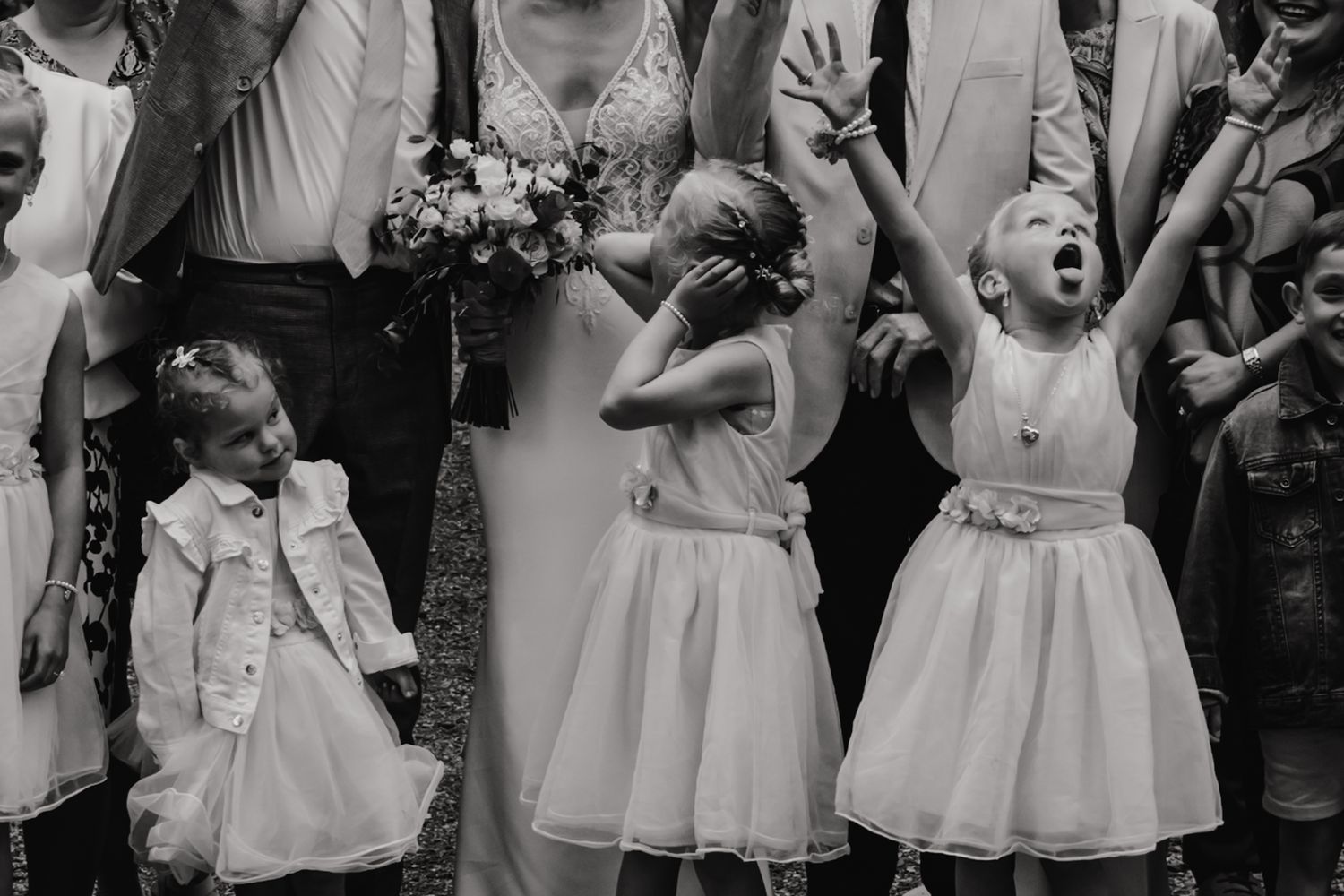 Black and white candid photo showing joyful expressions and laughter at a wedding celebration.