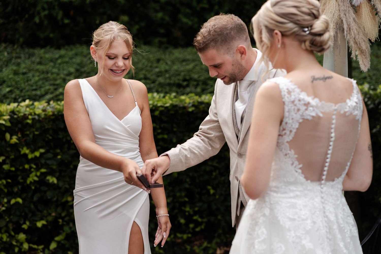 Wedding party members sharing a candid moment during outdoor celebrations.