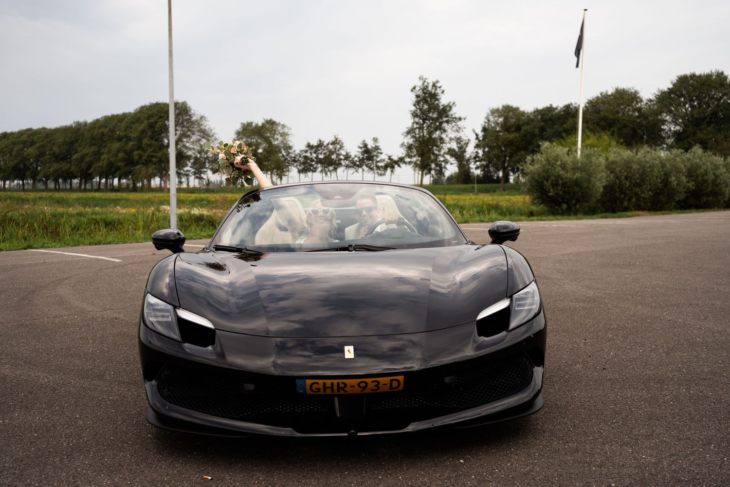 A sleek black Ferrari being driven by newlyweds on their wedding day.