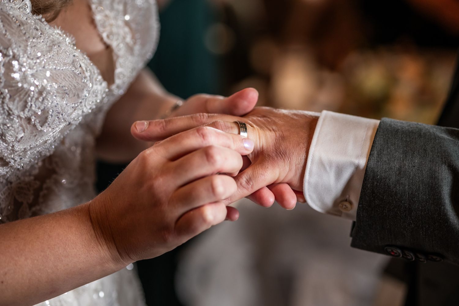 Close up of newly married couple's hands showing wedding rings during ceremony.