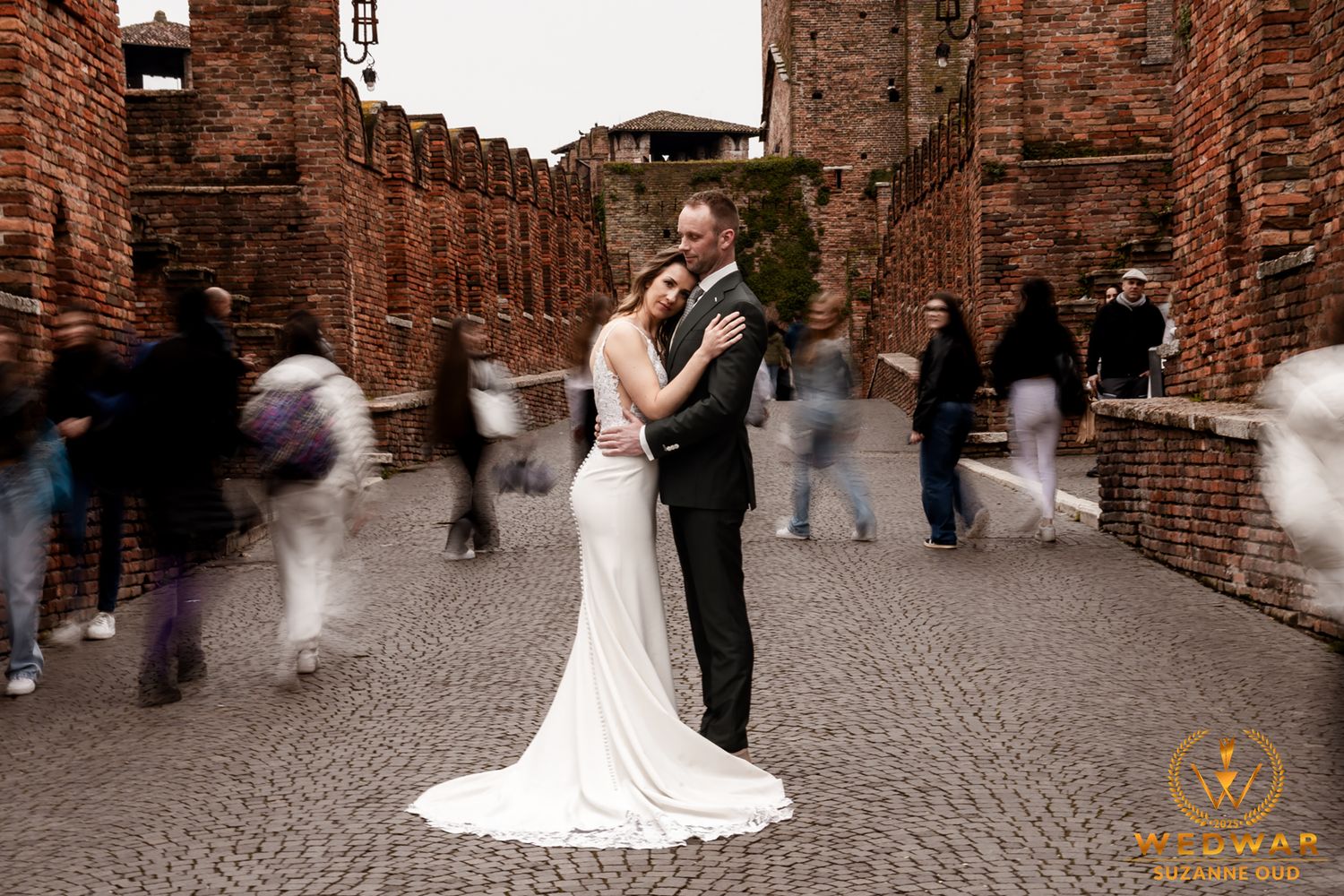 Panoramic sequence of a wedding couple and guests in a rustic brick courtyard setting.