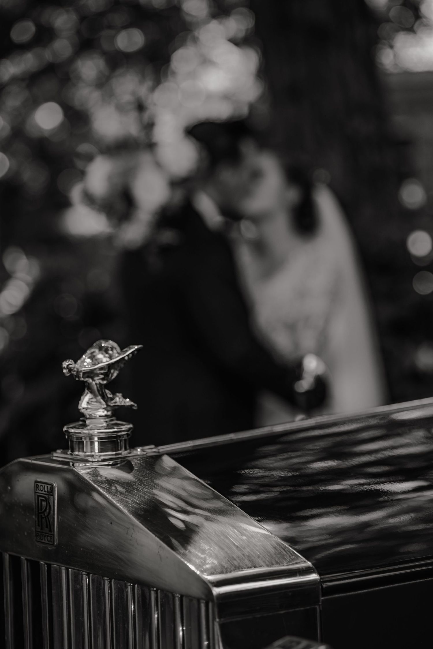 A series of black and white photos showing the iconic Spirit of Ecstasy hood ornament on a Rolls-Royce automobile.