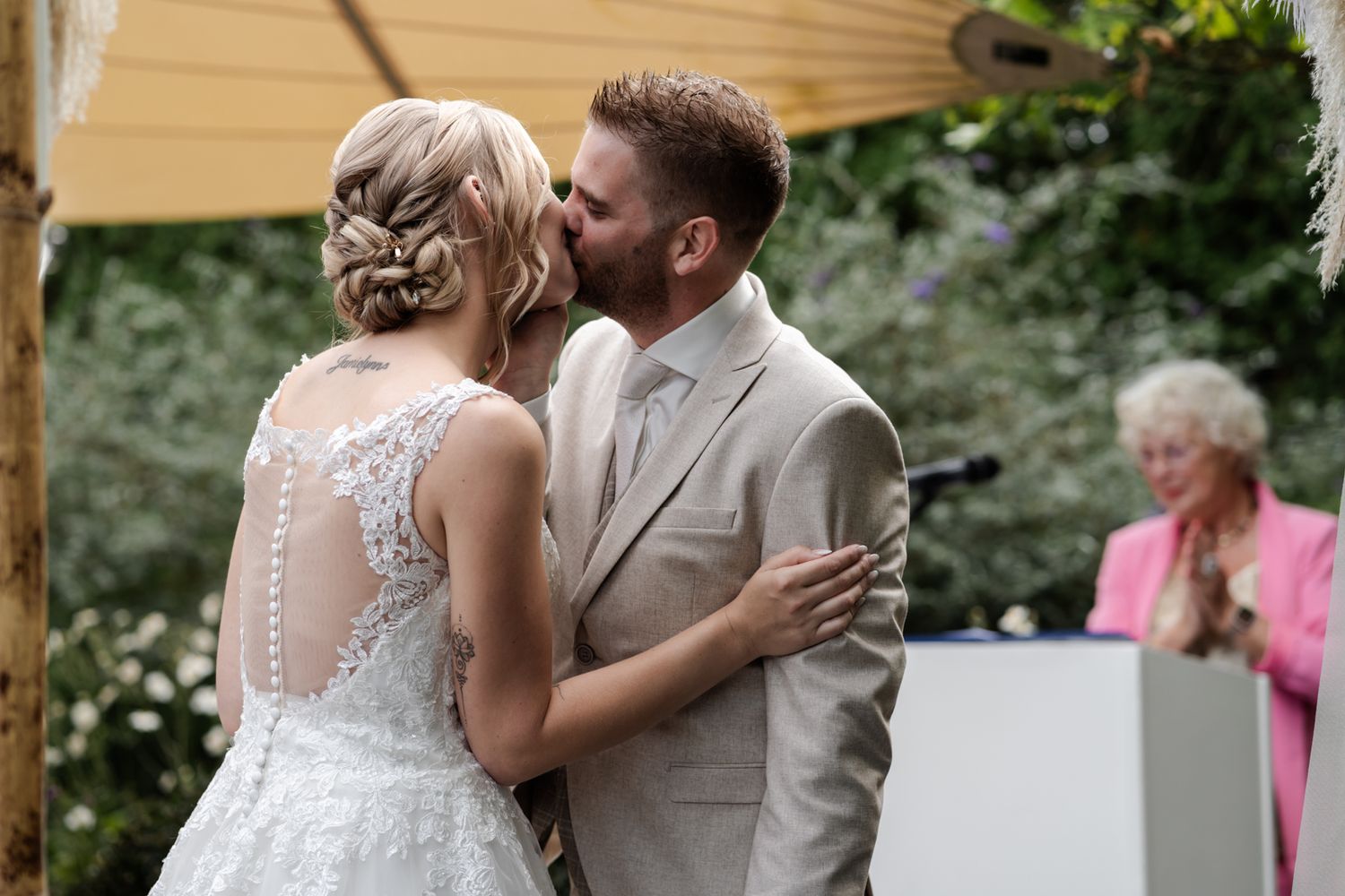 Intimate moment during outdoor garden wedding ceremony with elegant decor.