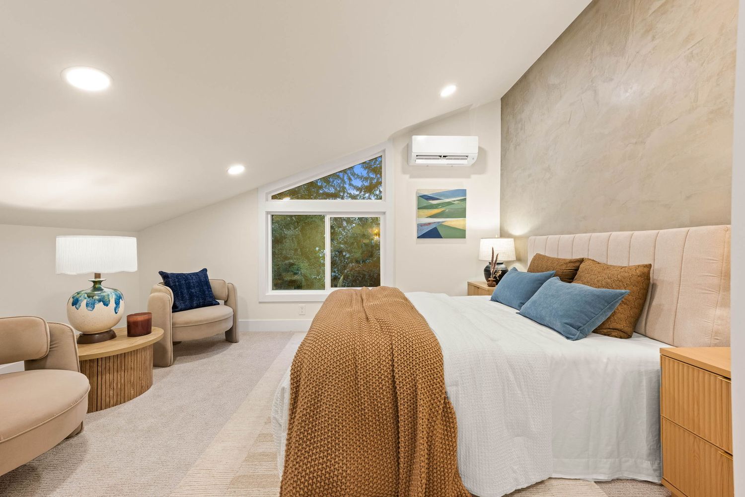 Cozy attic bedroom with sloped ceiling features tan and blue decor, recessed lighting, and built-in storage solutions.