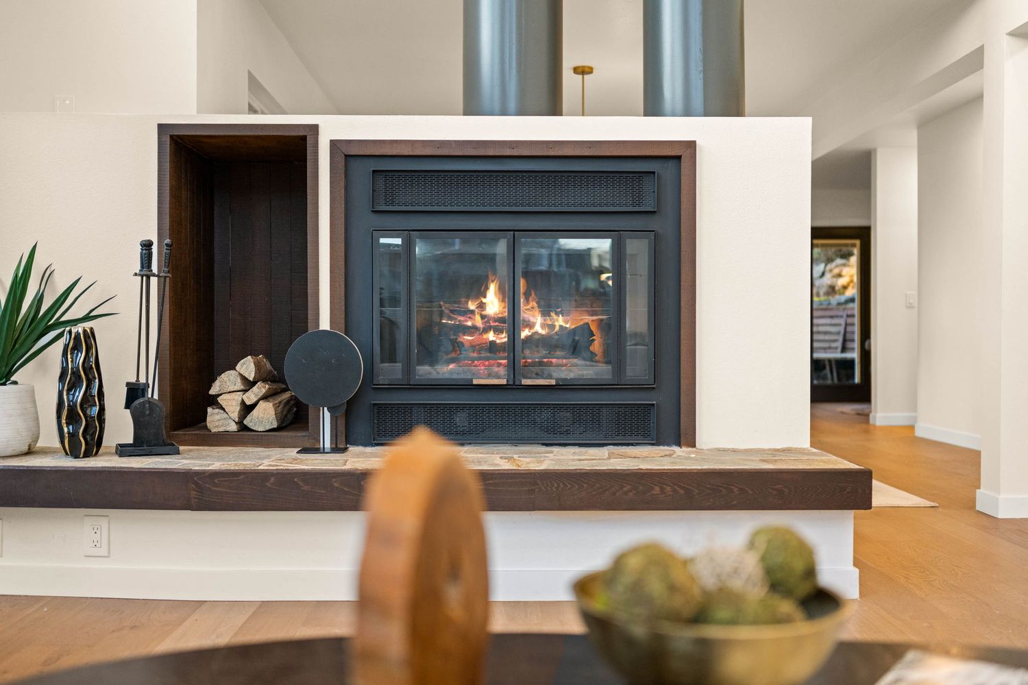 Contemporary fireplace installation with dark frame and white surround viewed from multiple angles.