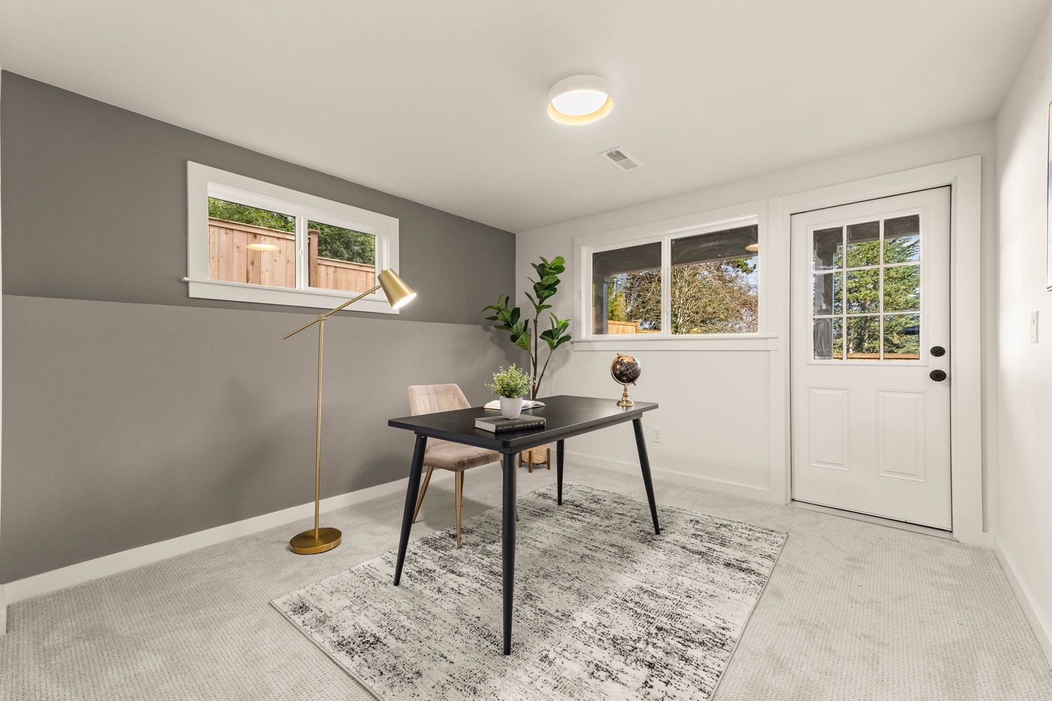 Modern open concept room with gray walls, white trim, and recessed lighting showcases hardwood flooring and bright windows.
