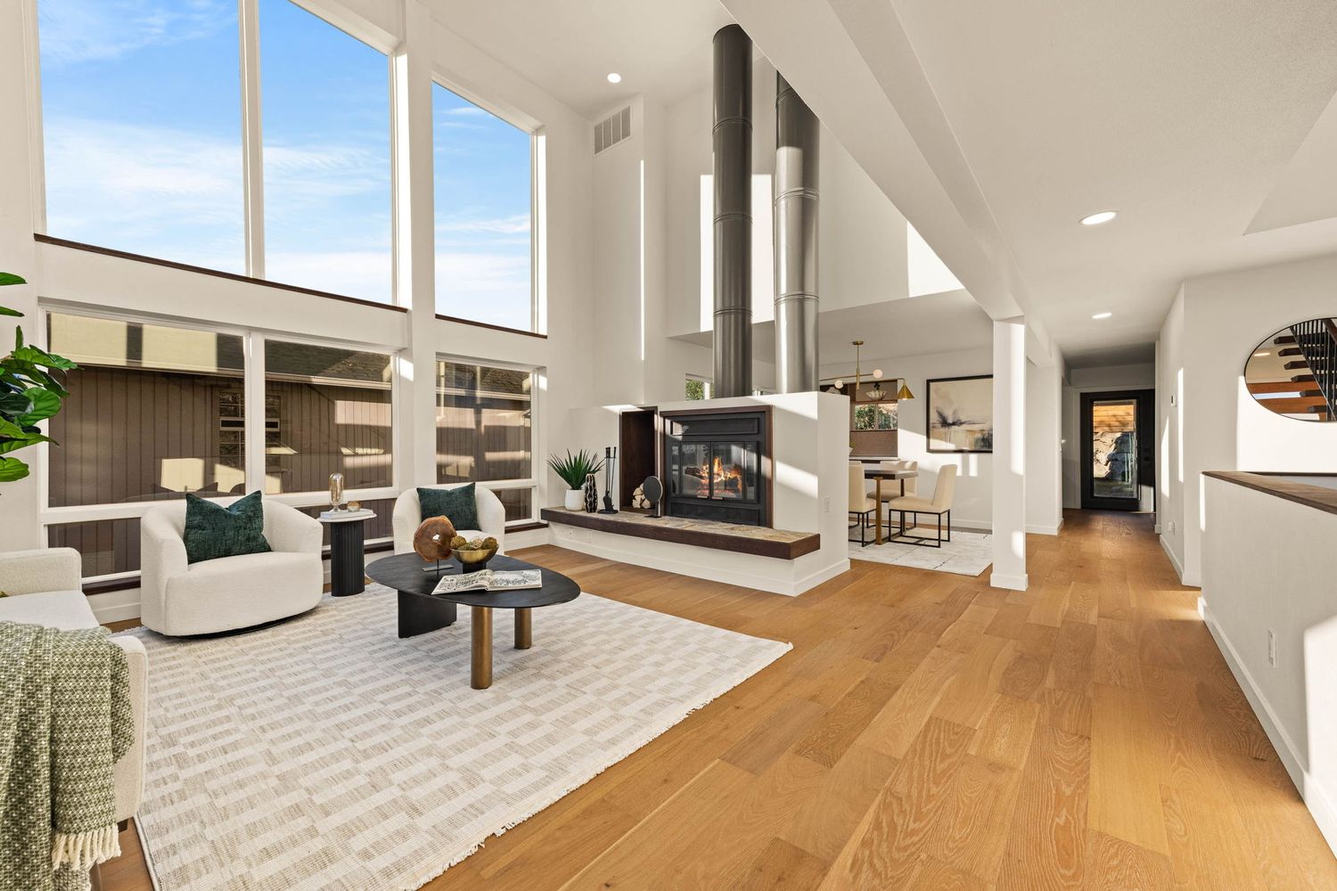 Modern open concept home interior with wood floors and white walls showcases a minimalist design aesthetic.