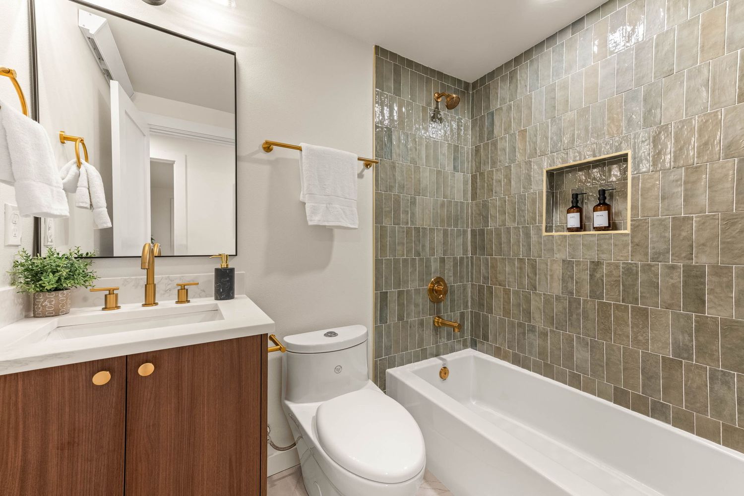 Modern bathroom interior with grey tile walls, white fixtures, wooden accents, and contemporary lighting design.