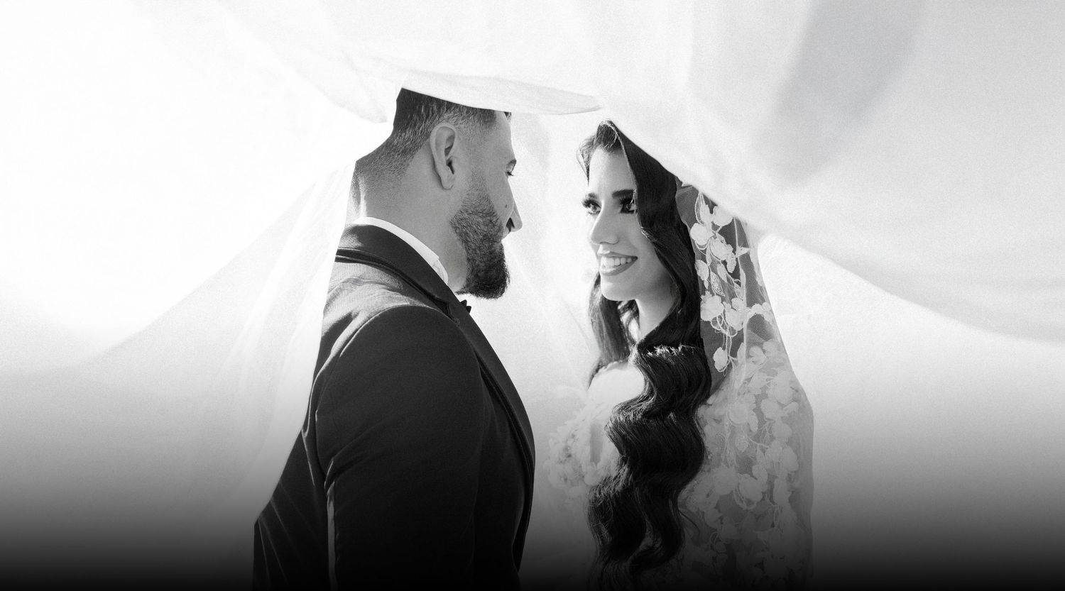 A bride and groom share an intimate moment in black and white wedding photography.