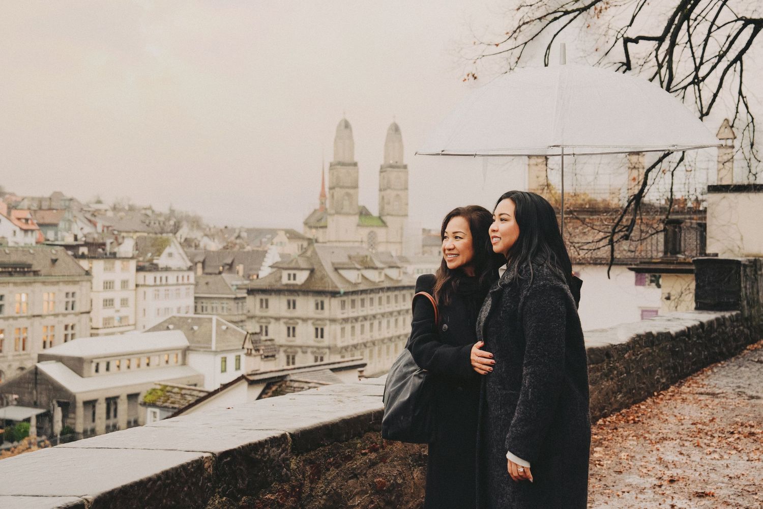 Mom and daughter together overlooking the Zurich skyline featuring the Grossmunster cathedral towers.
