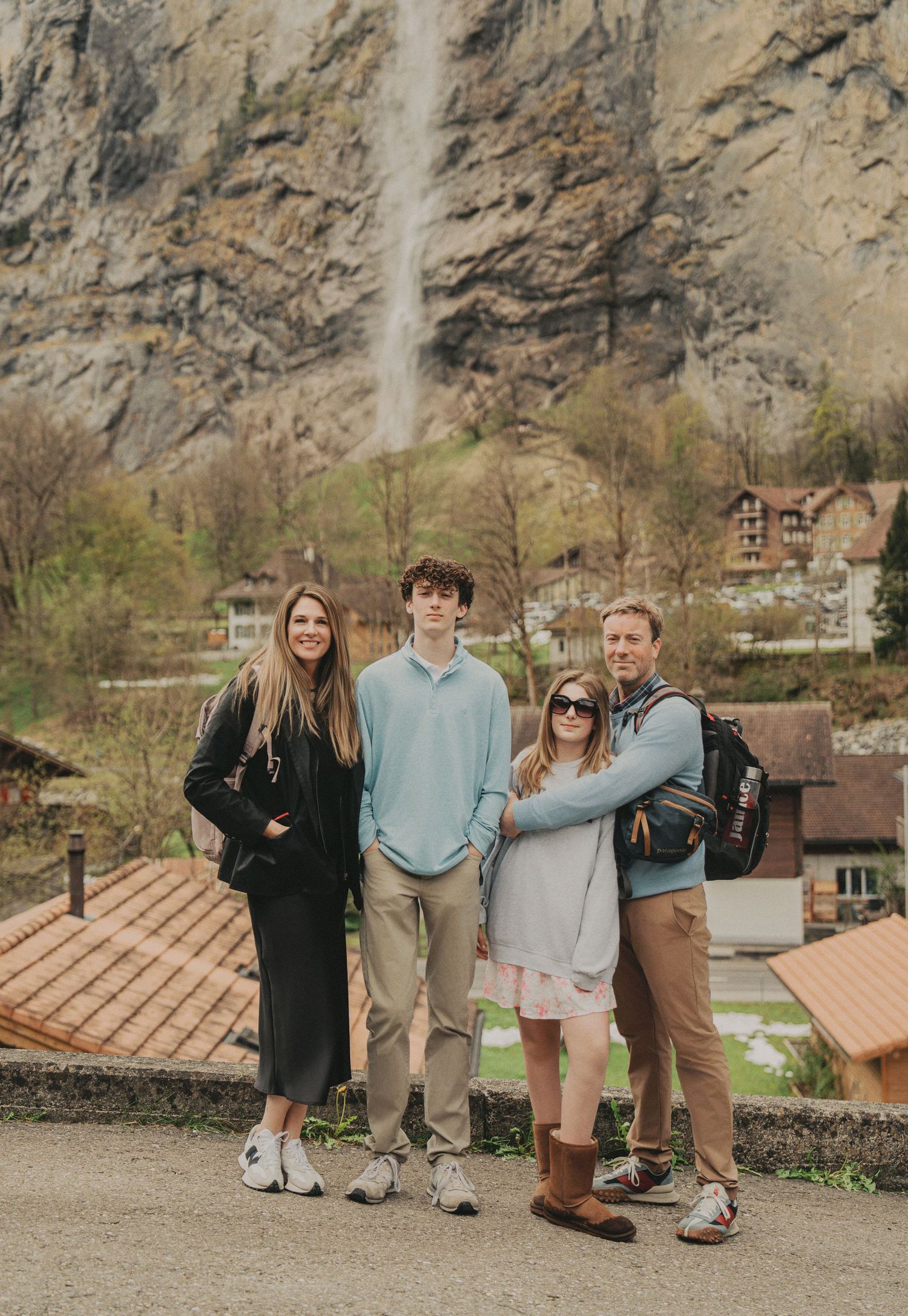 Family of four posing in front of a stunning waterfall in Lauterbrunnen, Switzerland.