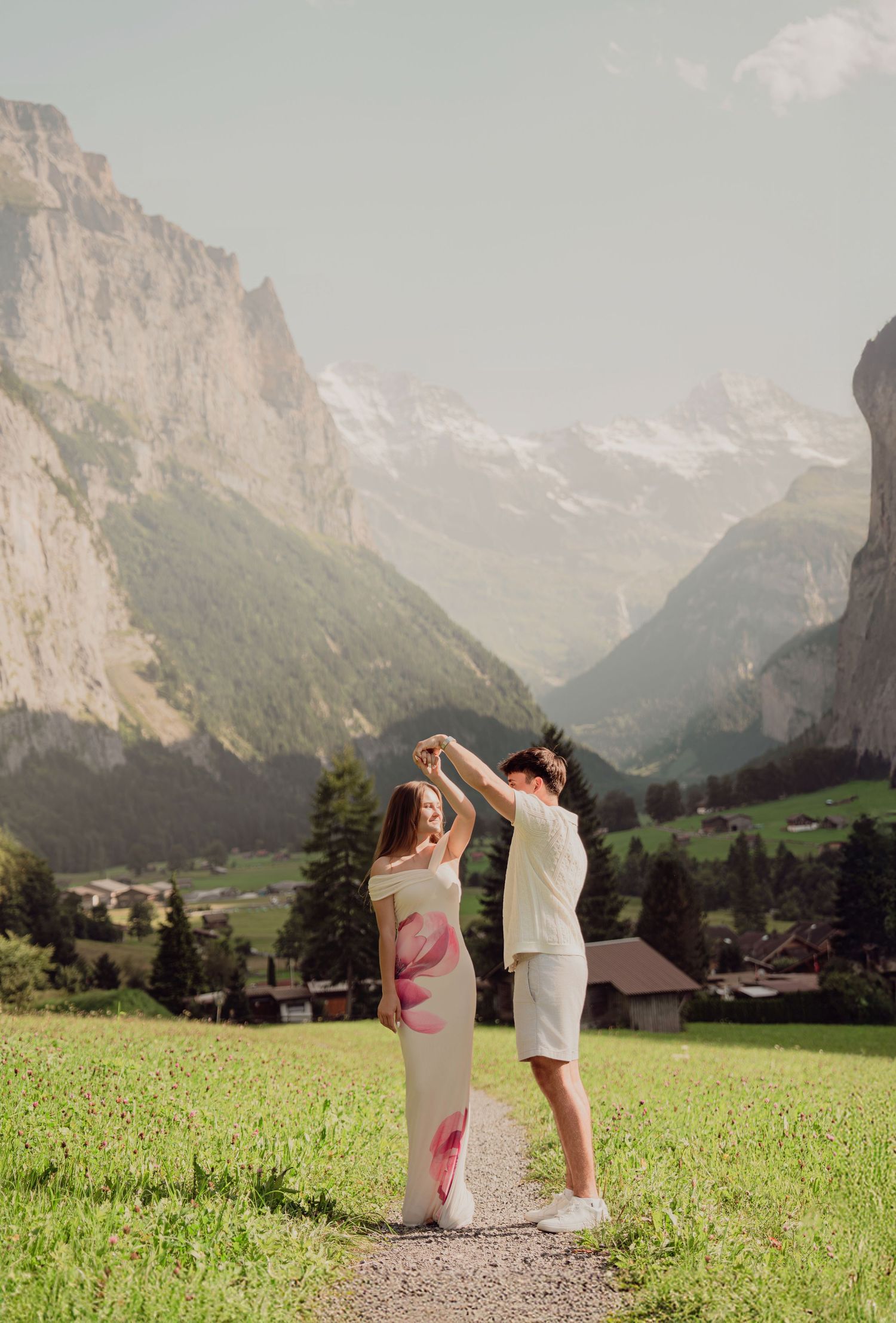 Couple dancing on a mountain path in Lauterbrunnen valley, Switzerland, with stunning alpine scenery.