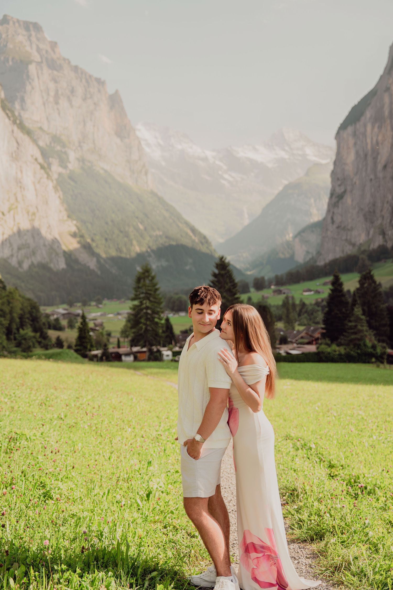 Romantic couple posing together in Lauterbrunnen valley with stunning Swiss Alps backdrop.