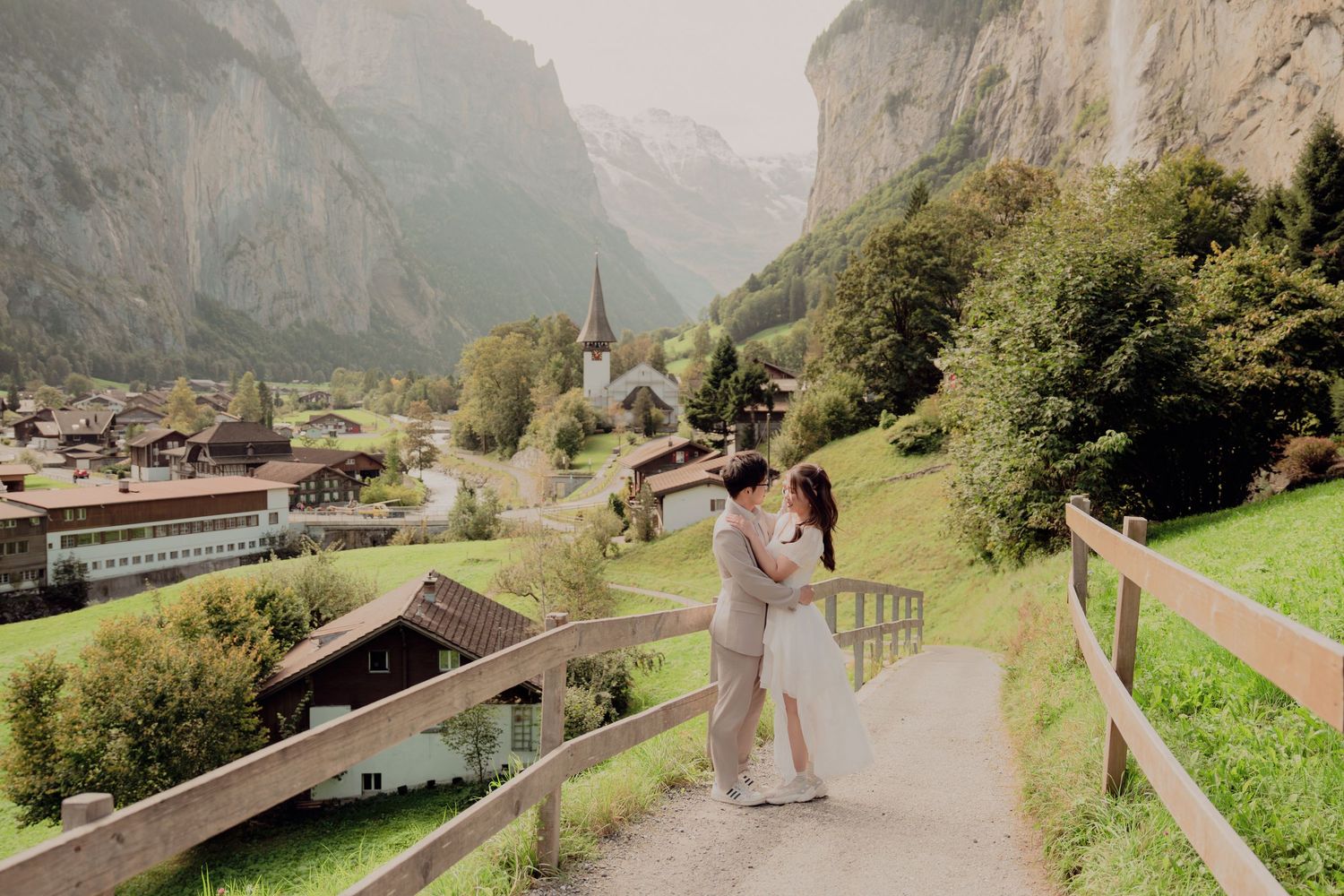 Romantic couple sharing a kiss on a scenic path overlooking the beautiful Lauterbrunnen valley Switzerland.