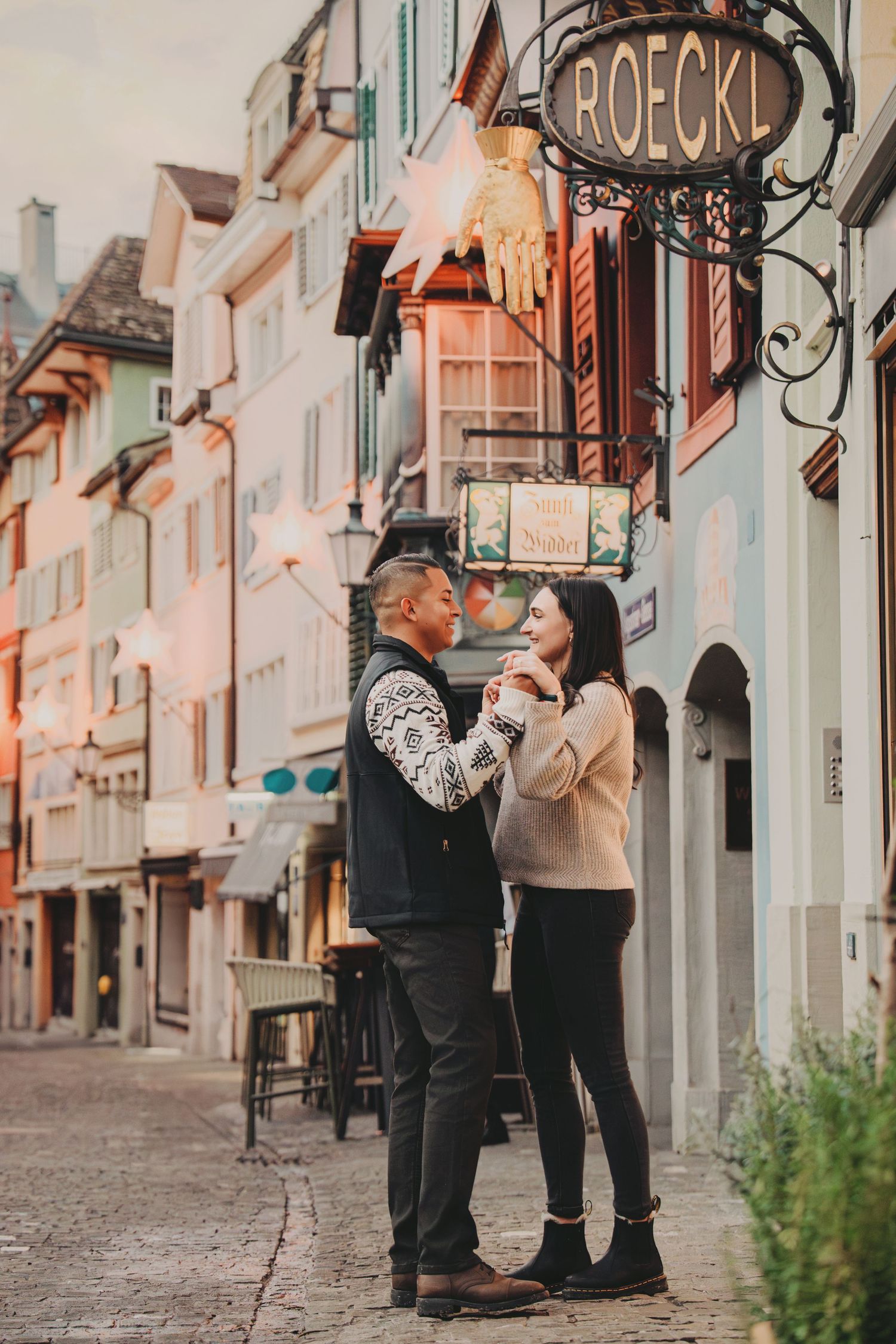 Romantic couple sharing an intimate moment on a picturesque old town street in Zurich, Switzerland.