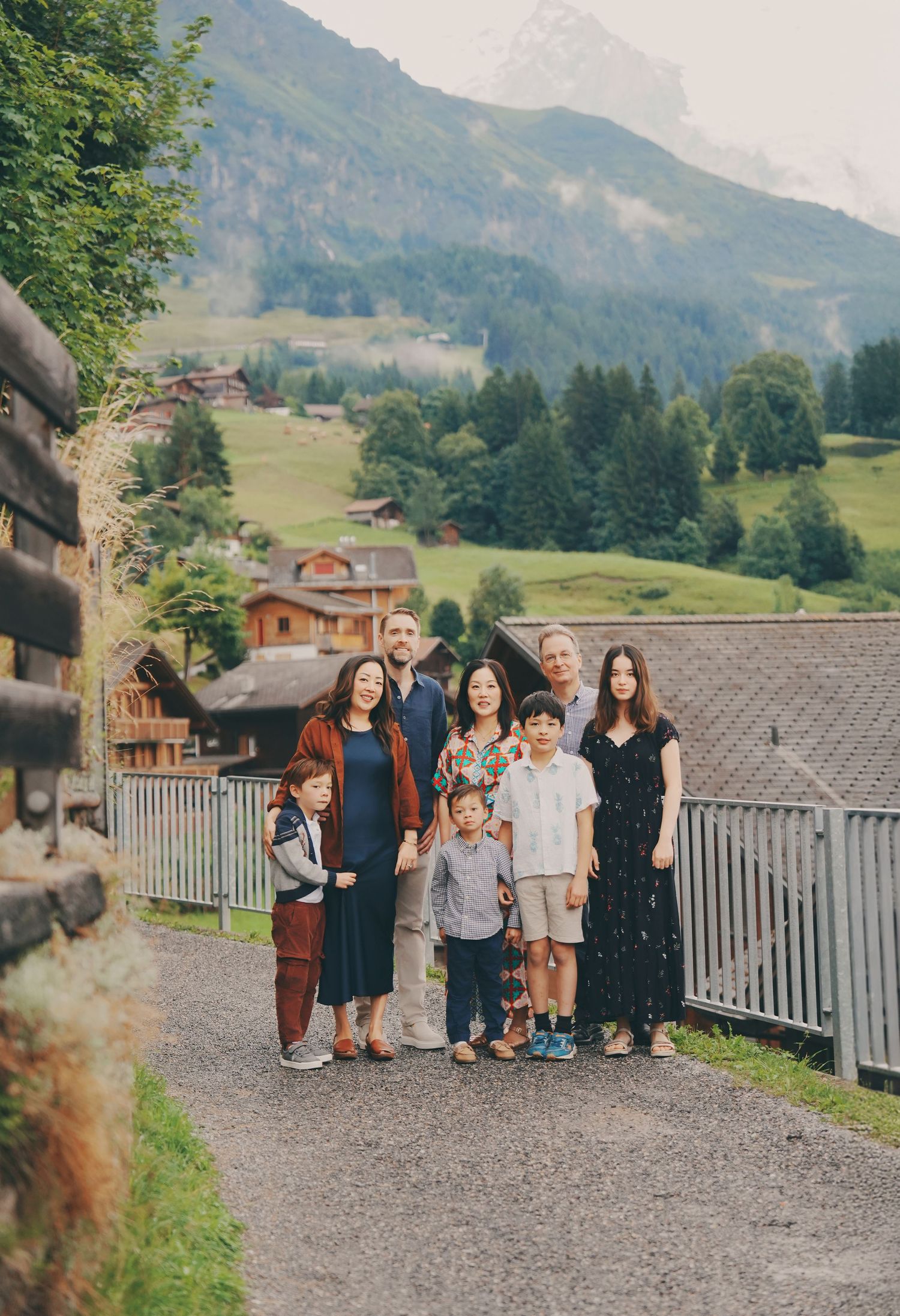Extended multigenerational family group posing on a scenic path in a lush Swiss Alpine valley.