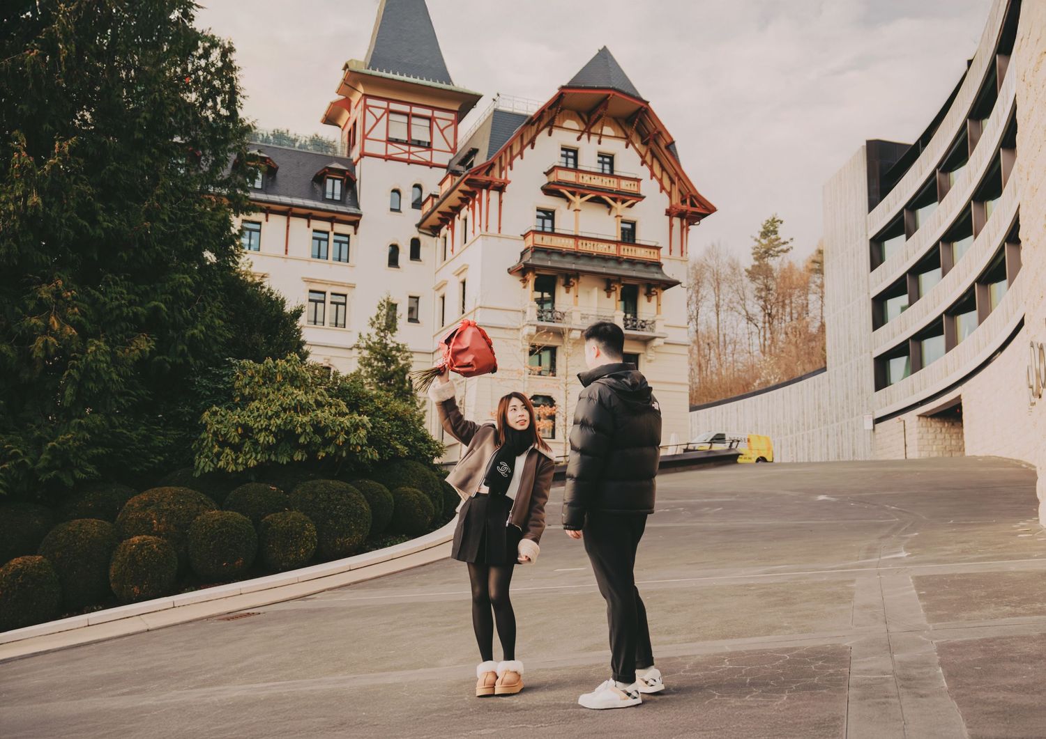 Three people taking a selfie outside a grand European-style hotel building.