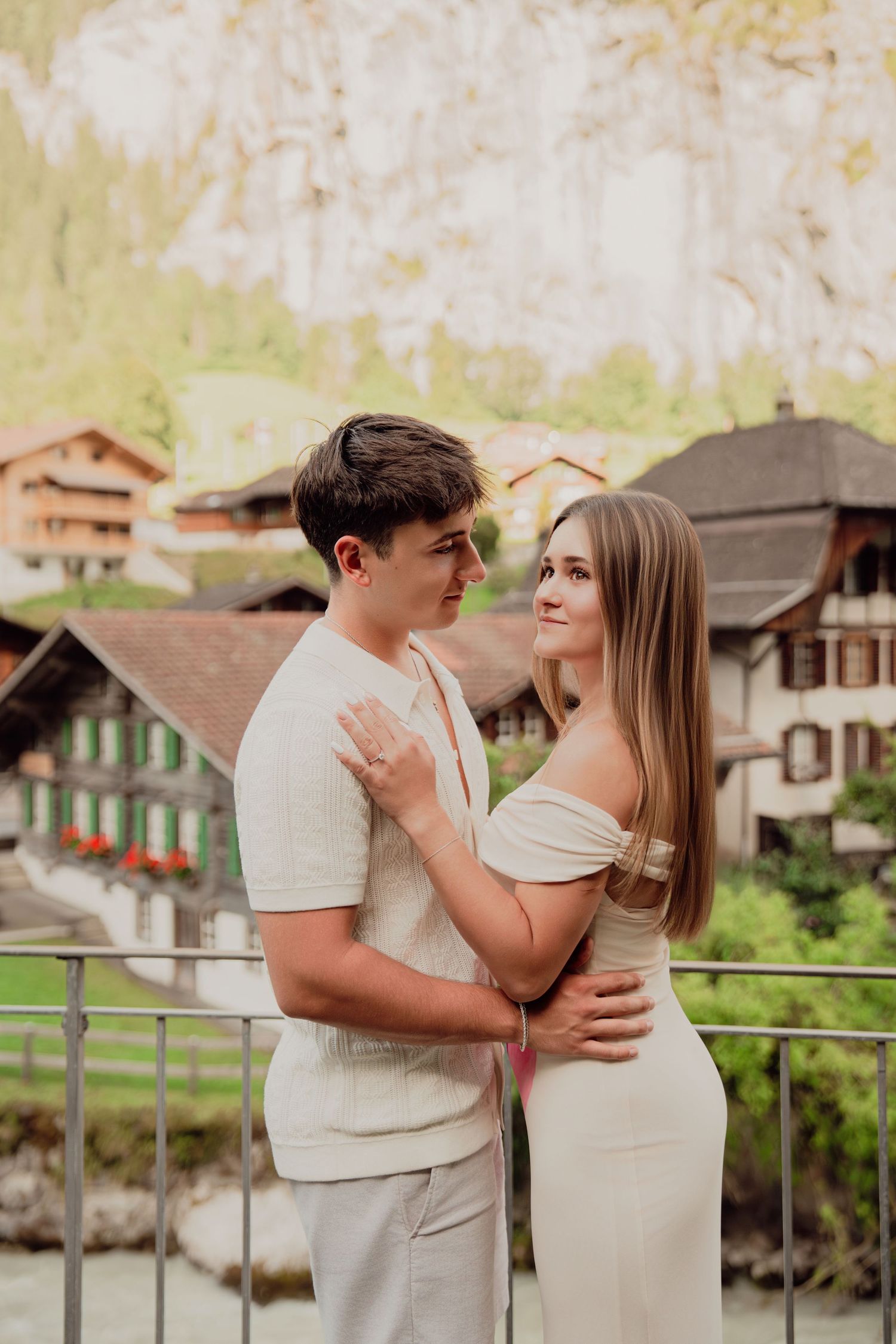 Young couple gazing at each other lovingly with Lauterbrunnen valley and waterfall backdrop.