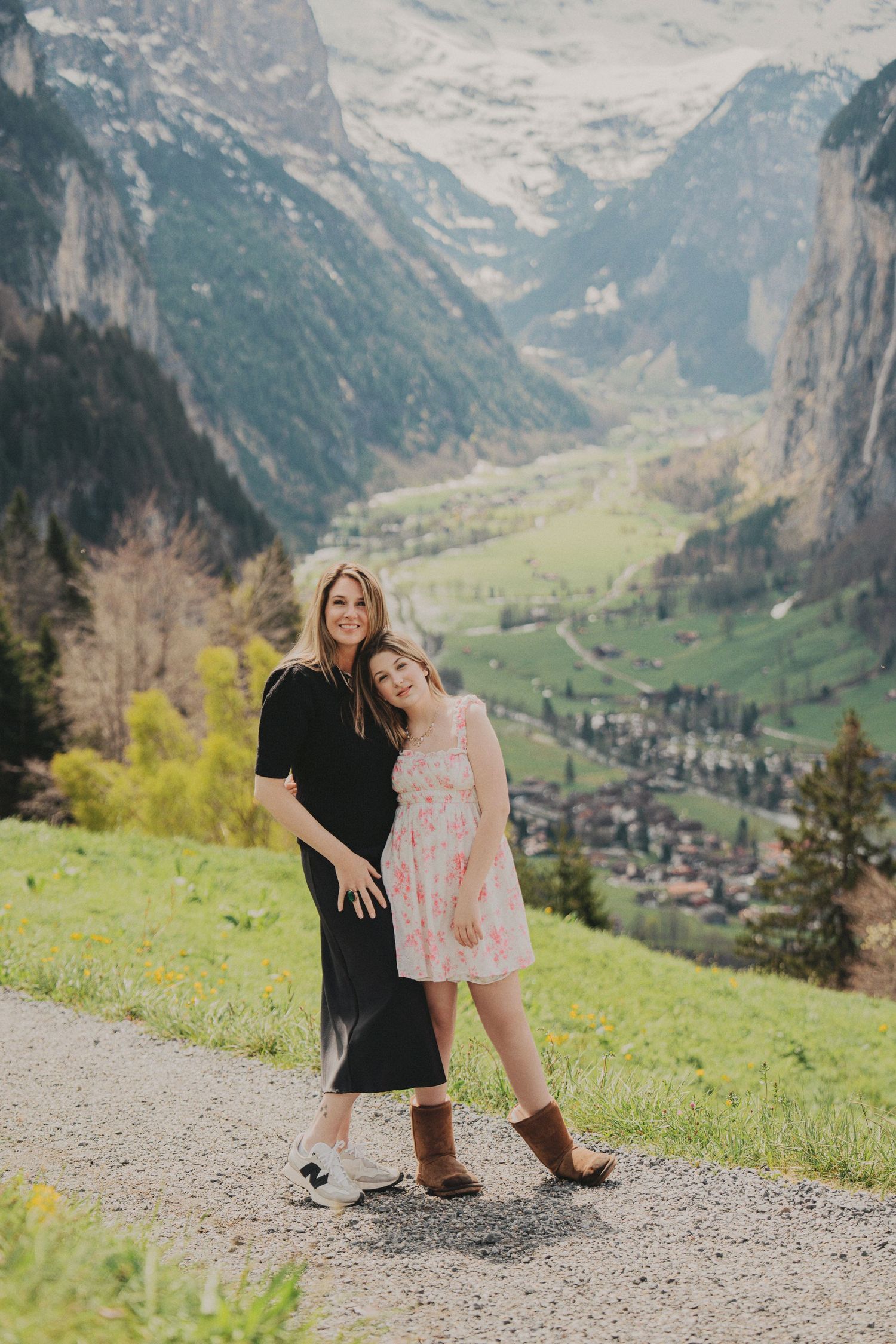Mother and daughter posing together on a mountain trail with Lauterbrunnen valley below.