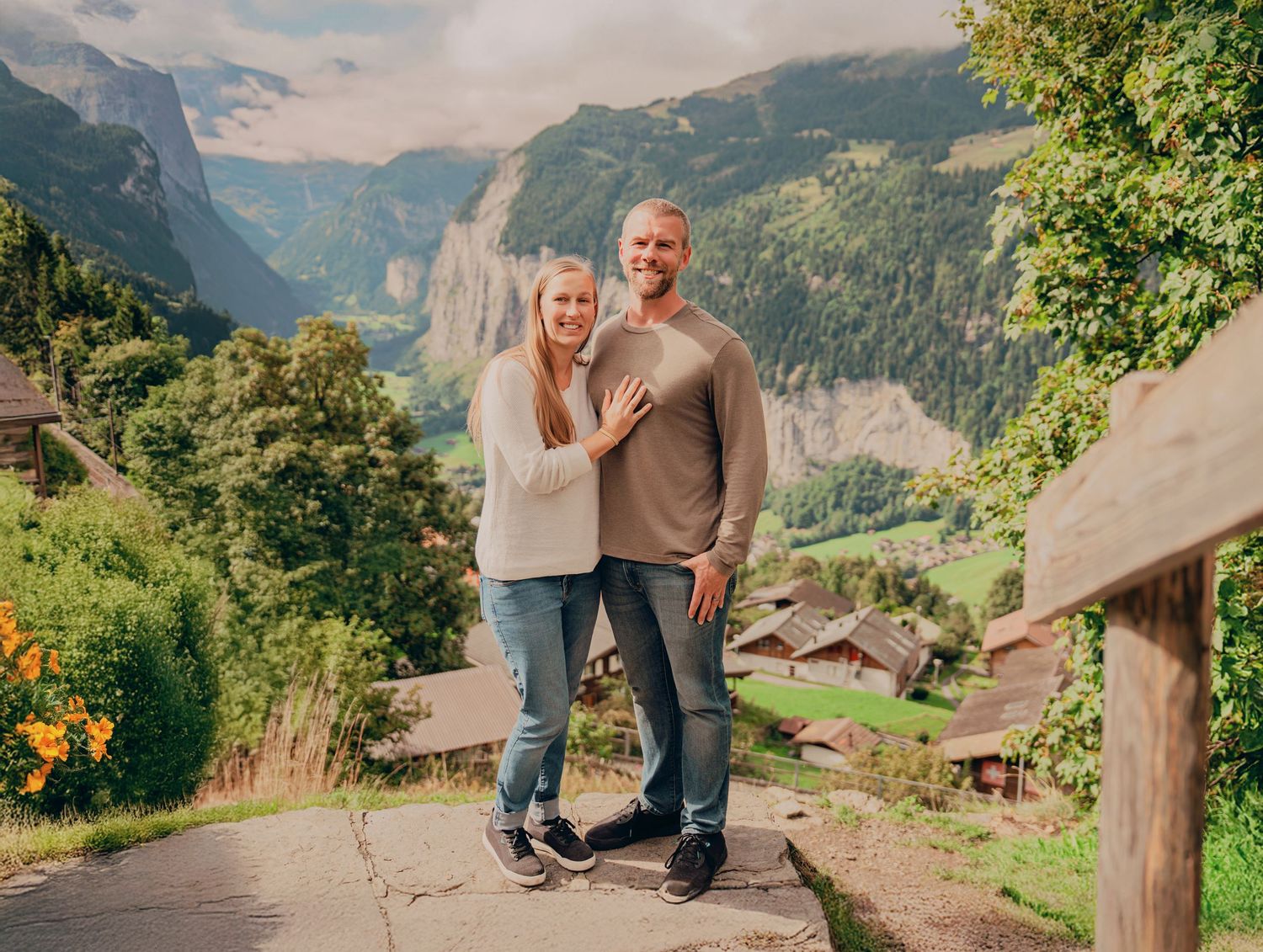 Couple smiling together on a scenic mountain path in Lauterbrunnen valley, Switzerland.