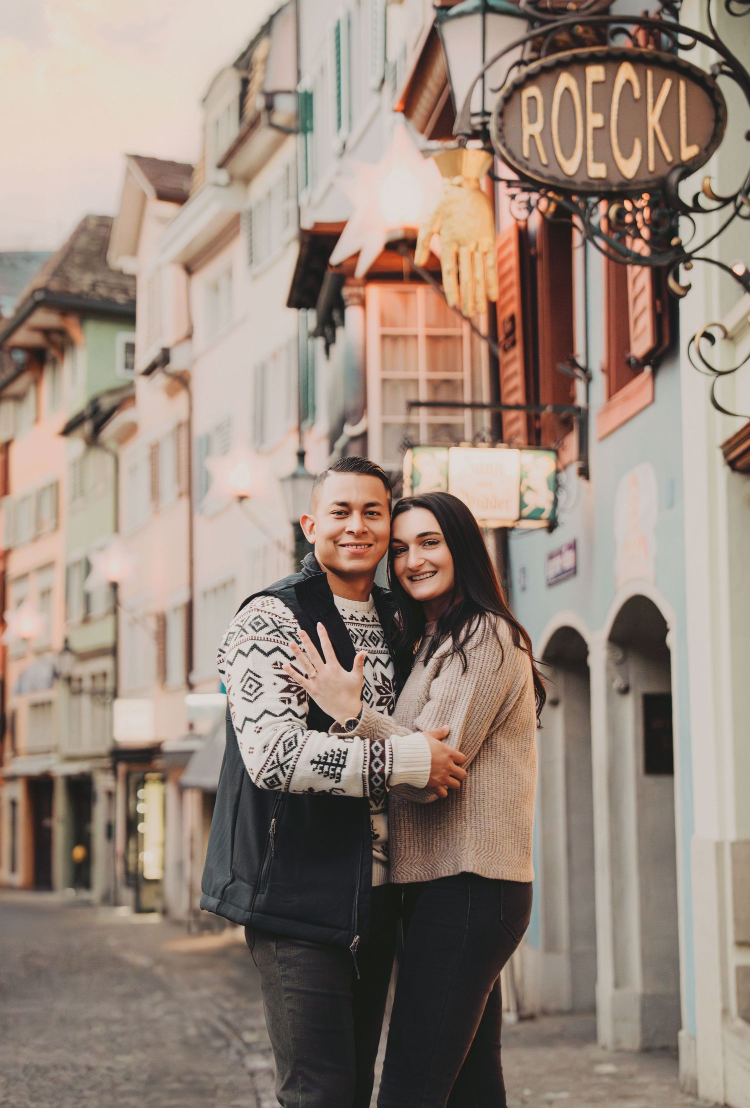 Happy couple embracing and smiling on a picturesque cobblestone street in Zurich's old town.