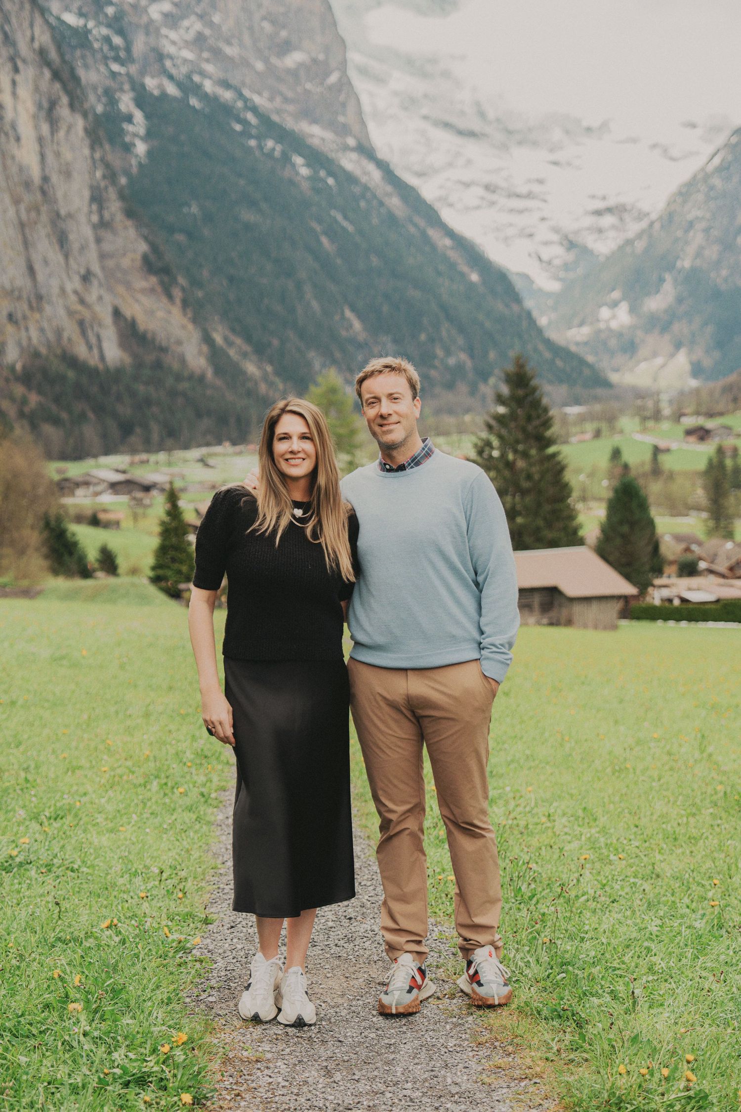 Smiling couple standing together on scenic mountain path in Lauterbrunnen Switzerland alpine valley.