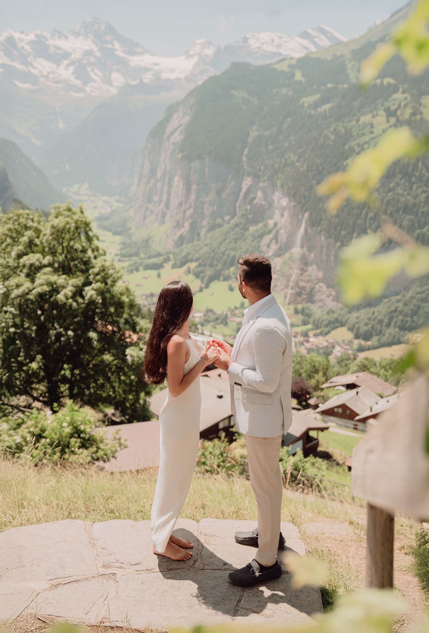 Couple exchanging vows on a stone platform overlooking the stunning Lauterbrunnen valley Switzerland.