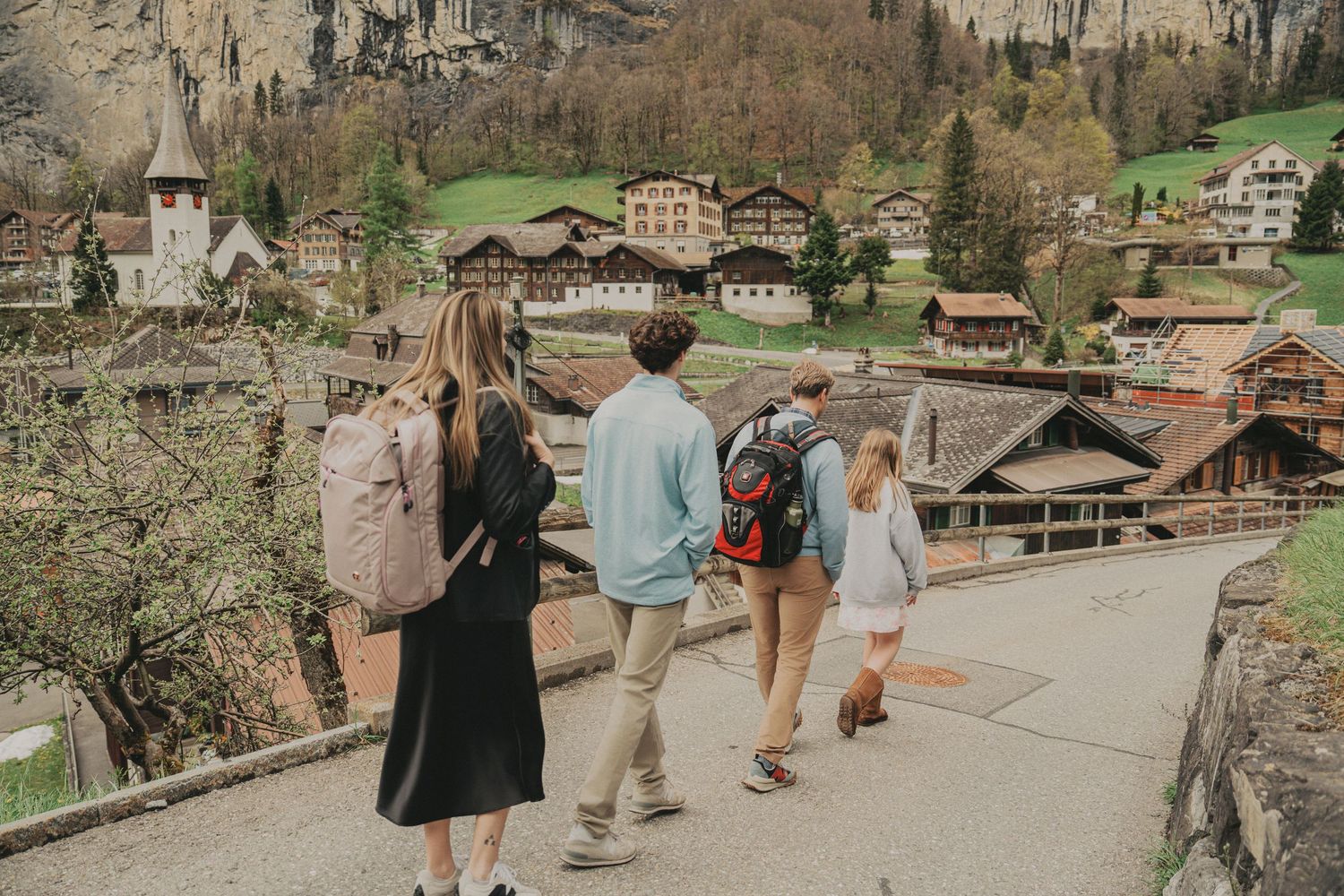 Family walking along a scenic path through a picturesque Swiss mountain village.