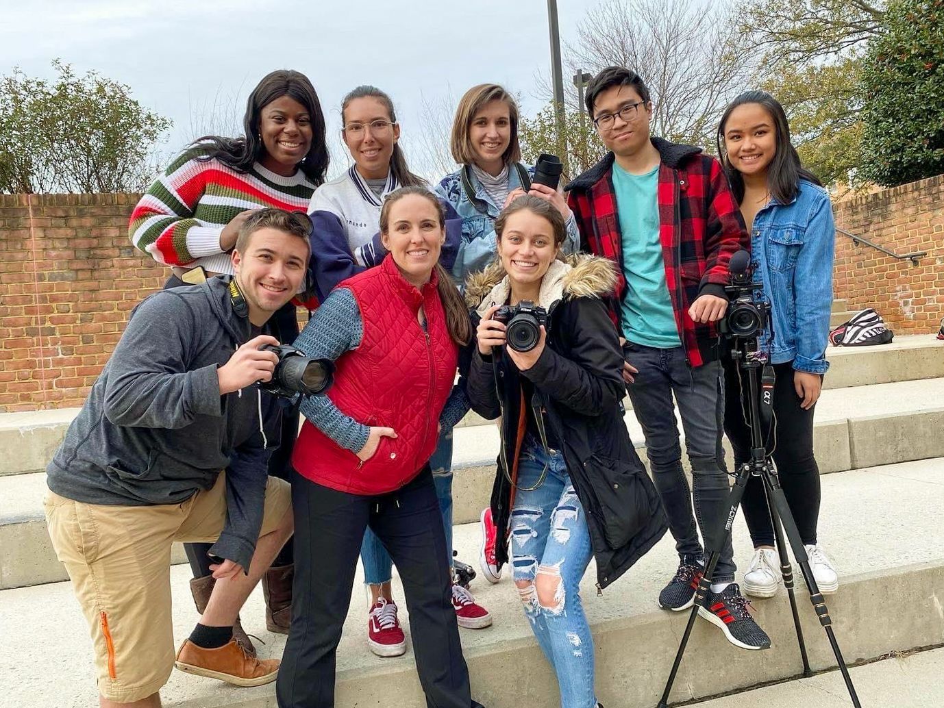 Group of photography students practicing outdoor shooting techniques on campus.