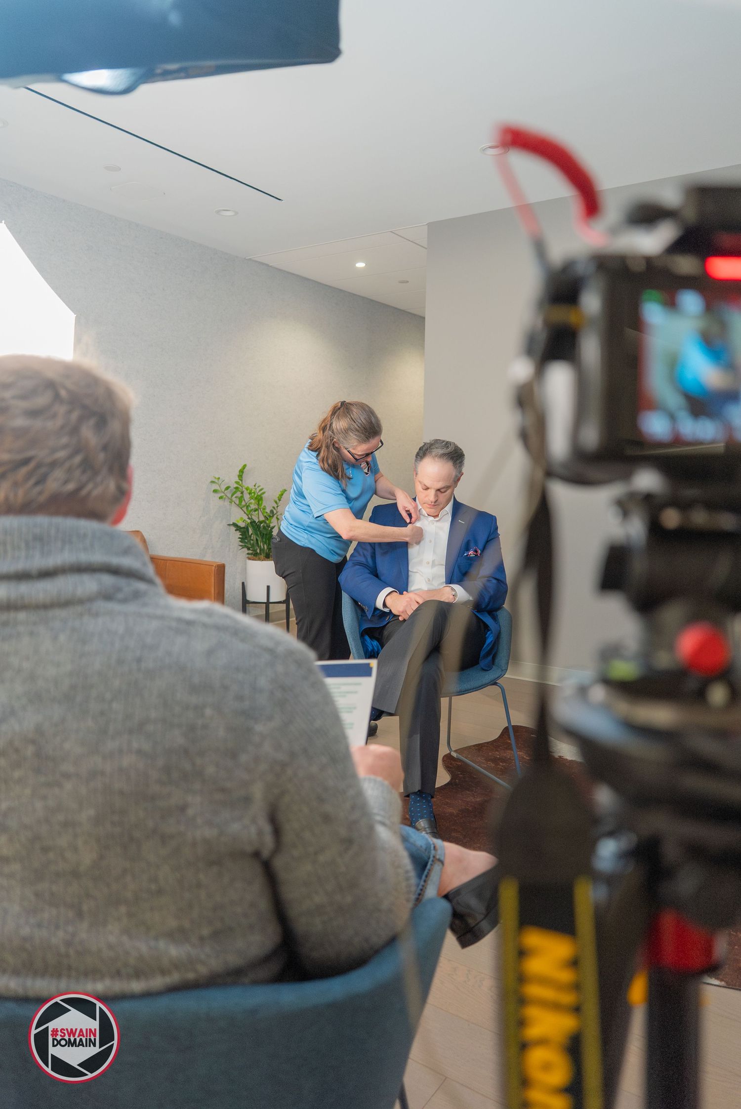 Bethany Swain sets up microphone for client for an interview.