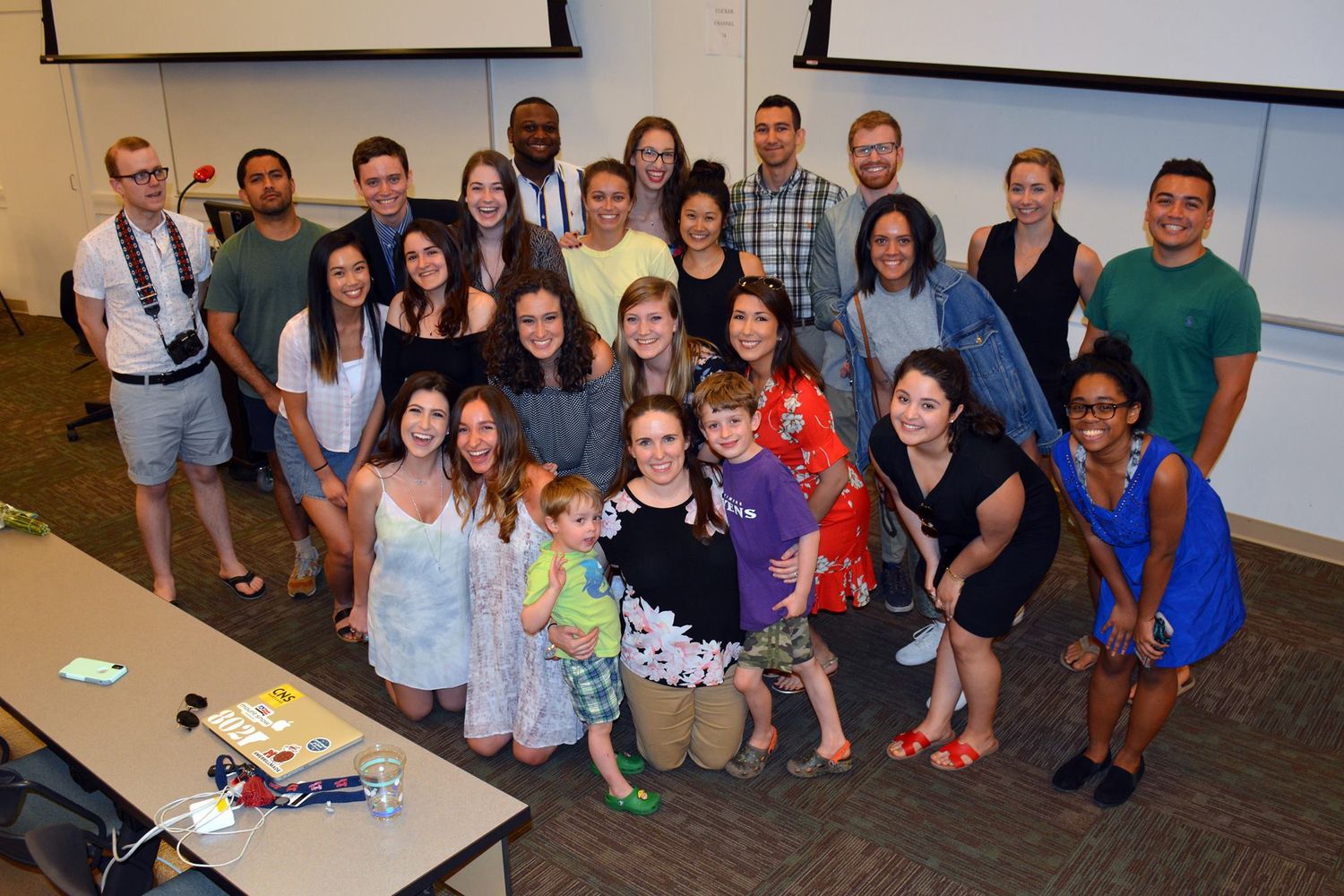 Group photo showing students and faculty gathered together in a classroom setting.