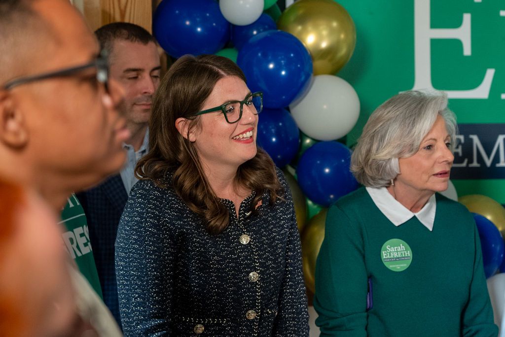 Attendees gathered at a political event with campaign signage and decorations.