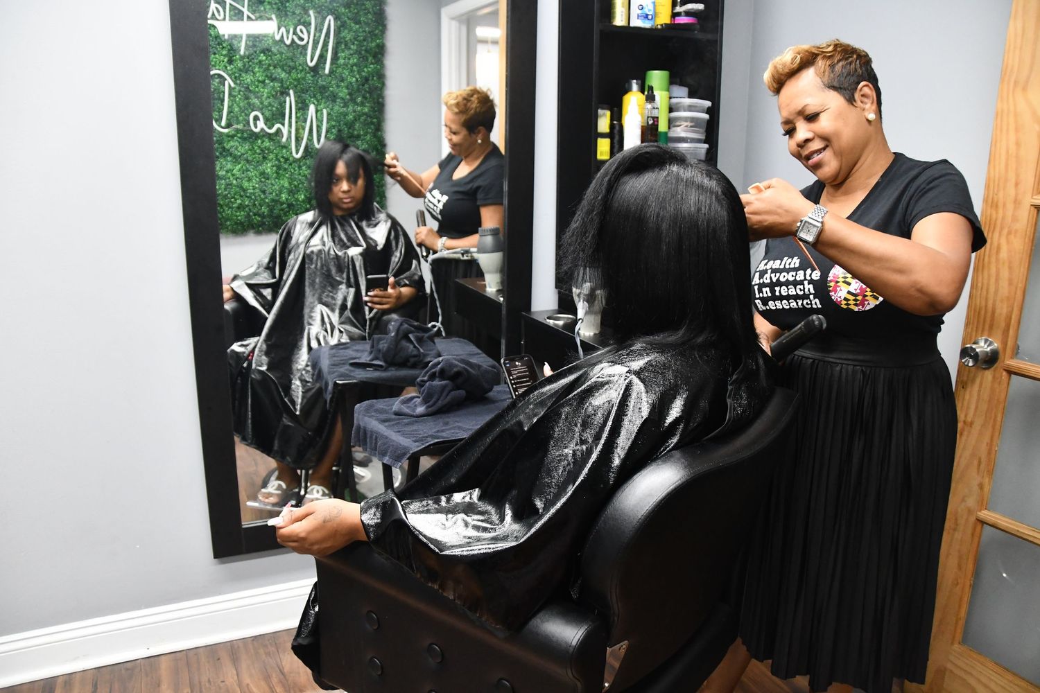 People gathered in a dimly lit salon setting with styling chairs.