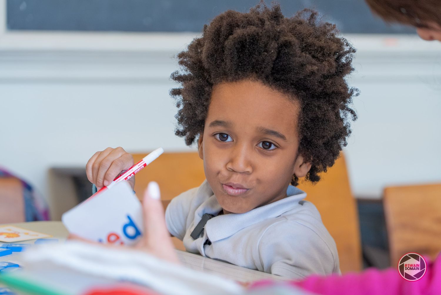 Students engage in creative learning activities at elementary school desks with colorful educational materials.
