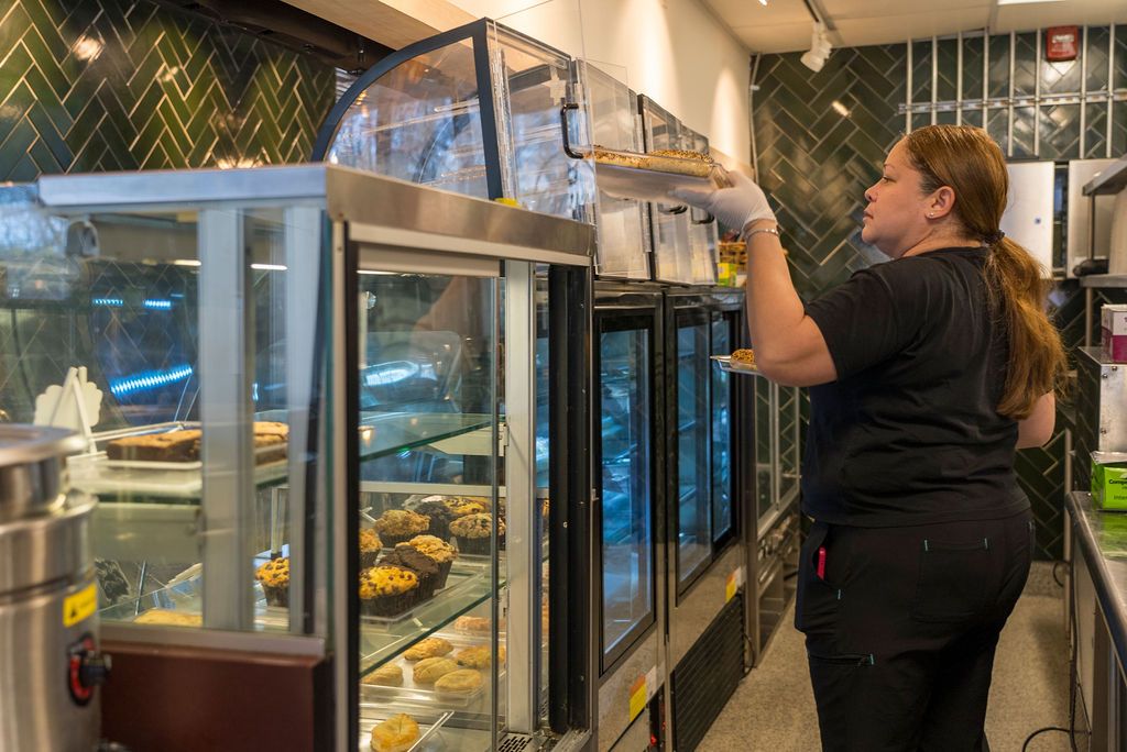 Interior of a modern cafe with herringbone tile and display cases.