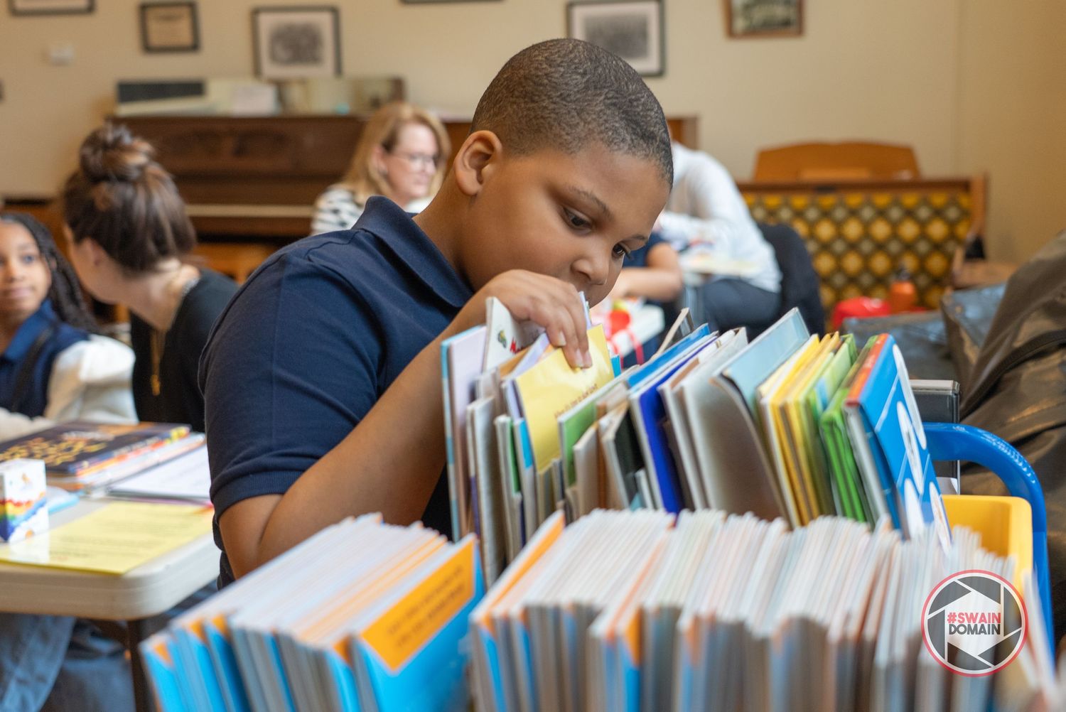 Students reading and studying with books in classroom setting.