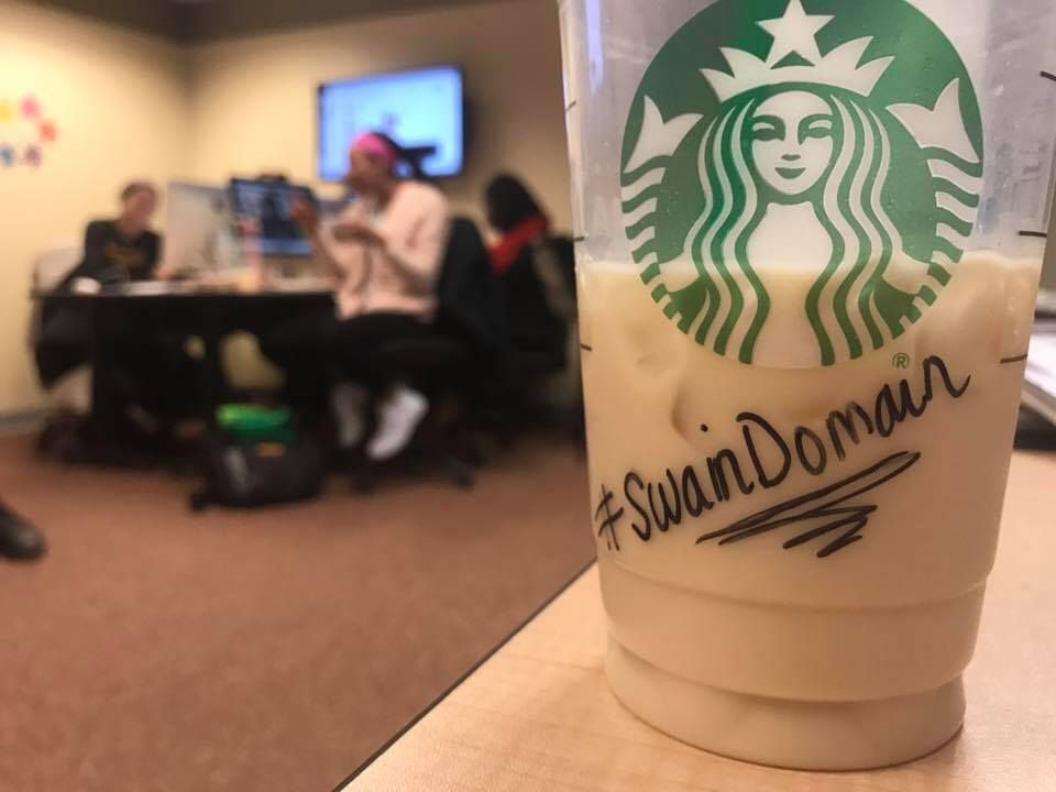Row of Starbucks coffee cups with custom names written on them.
