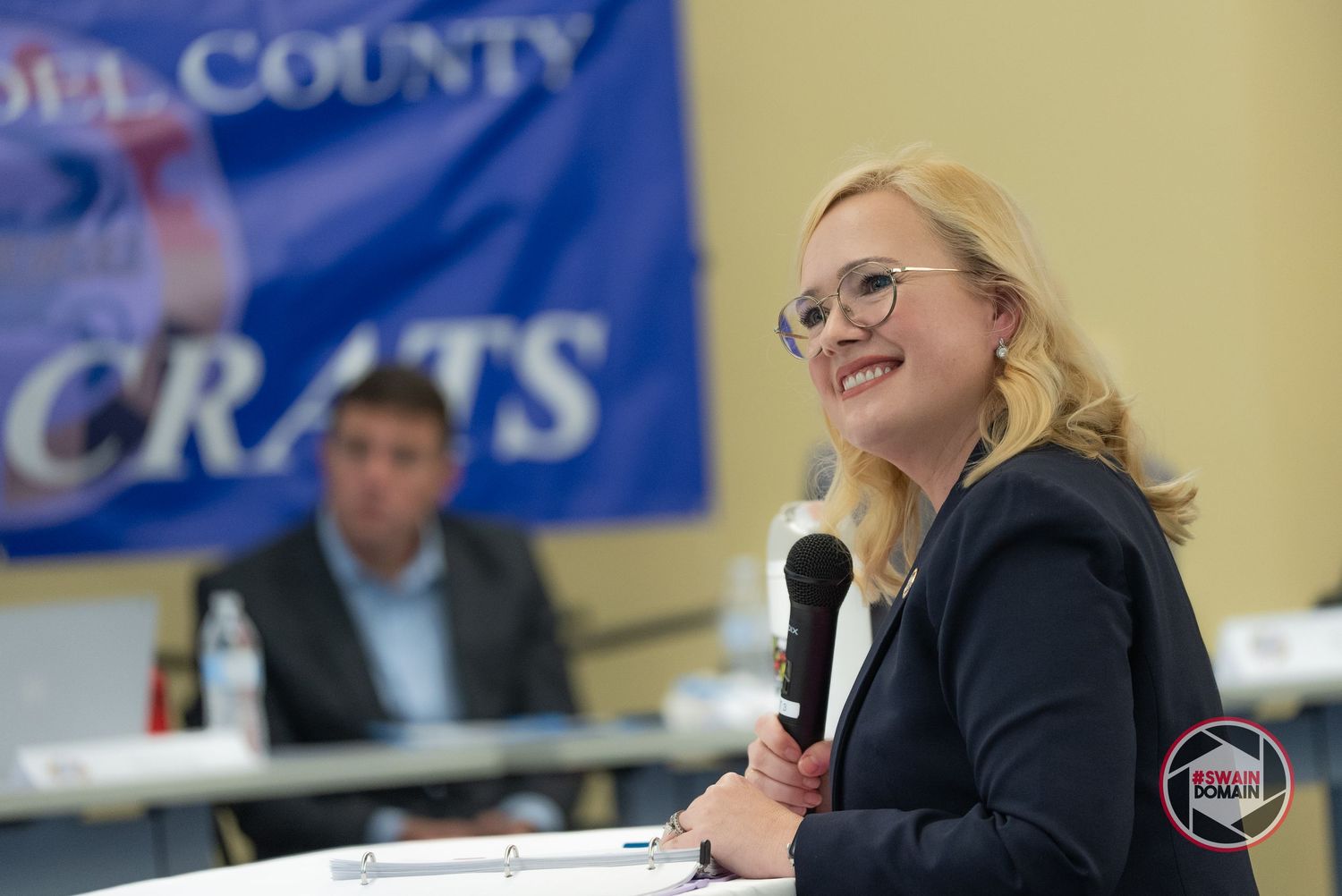 Campaign event with county signage and supporters in attendance.