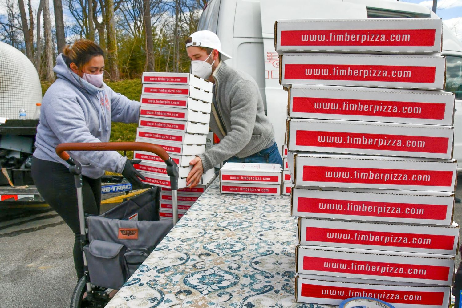Row of pizza boxes stacked on tables with Hungry Pizza branding visible.