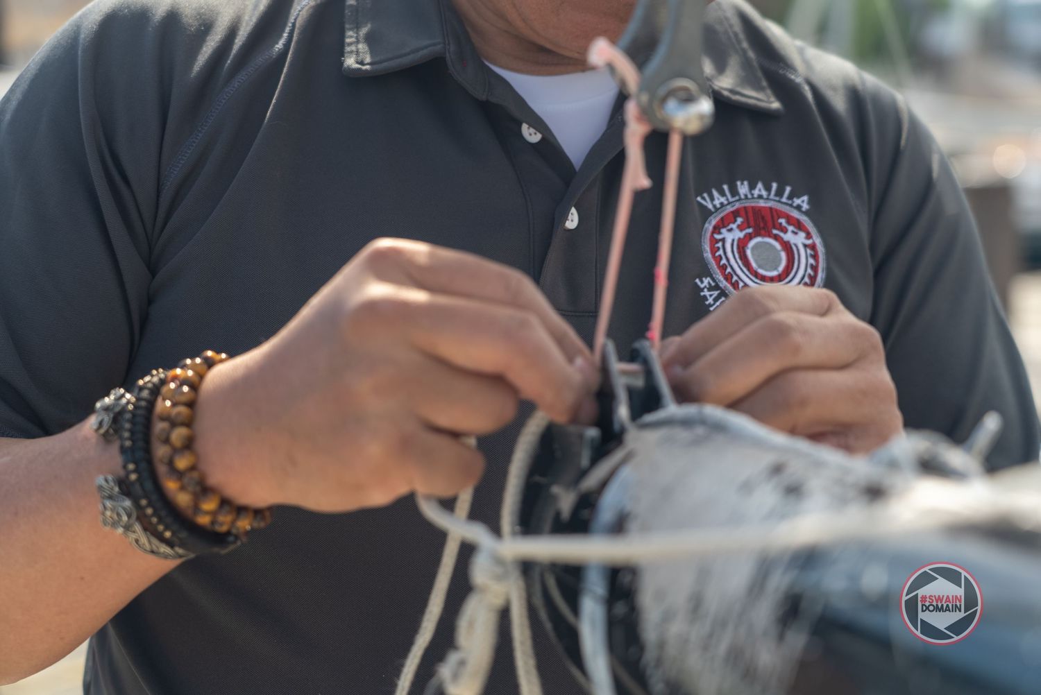 Person in a black shirt demonstrates various steps of assembling or handling a mechanical device.