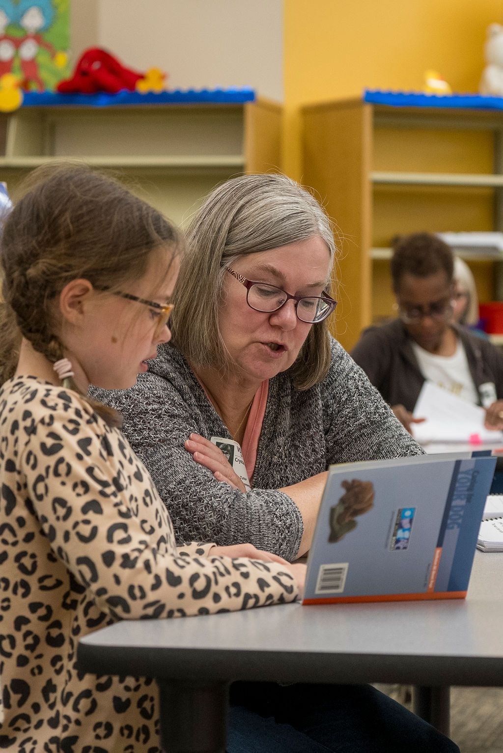 People reading and collaborating over educational materials at a table.