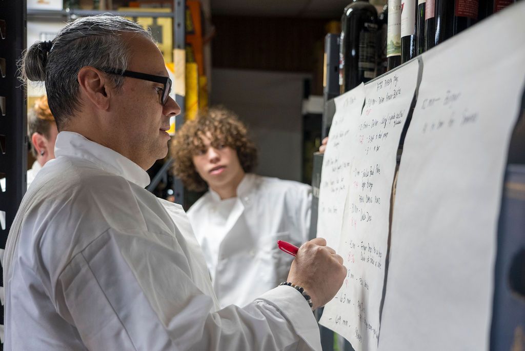 Culinary professionals gathered around whiteboards during a planning session.