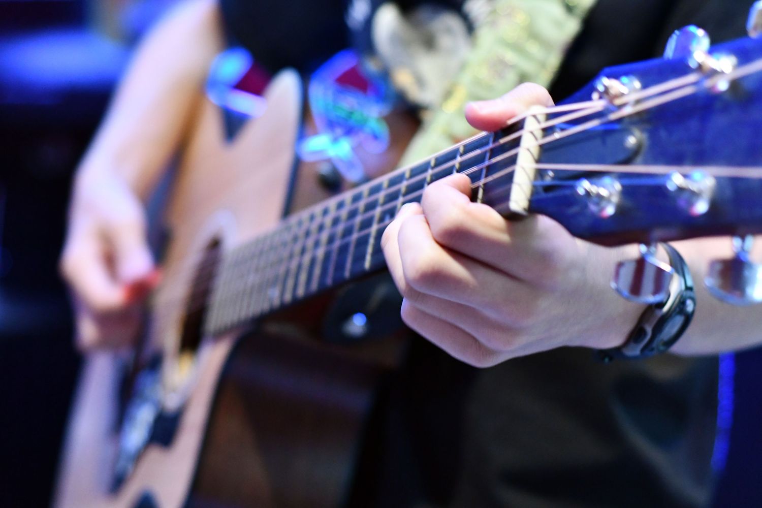 Close-up shots of hands playing musical instruments on stage.