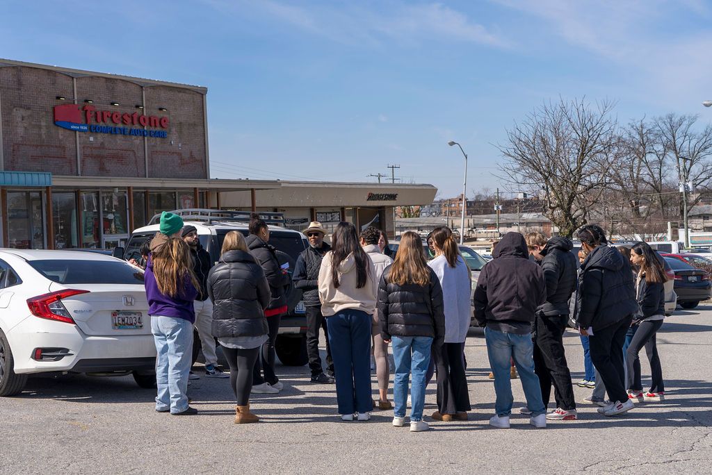 Long line of people waiting outside a commercial building.