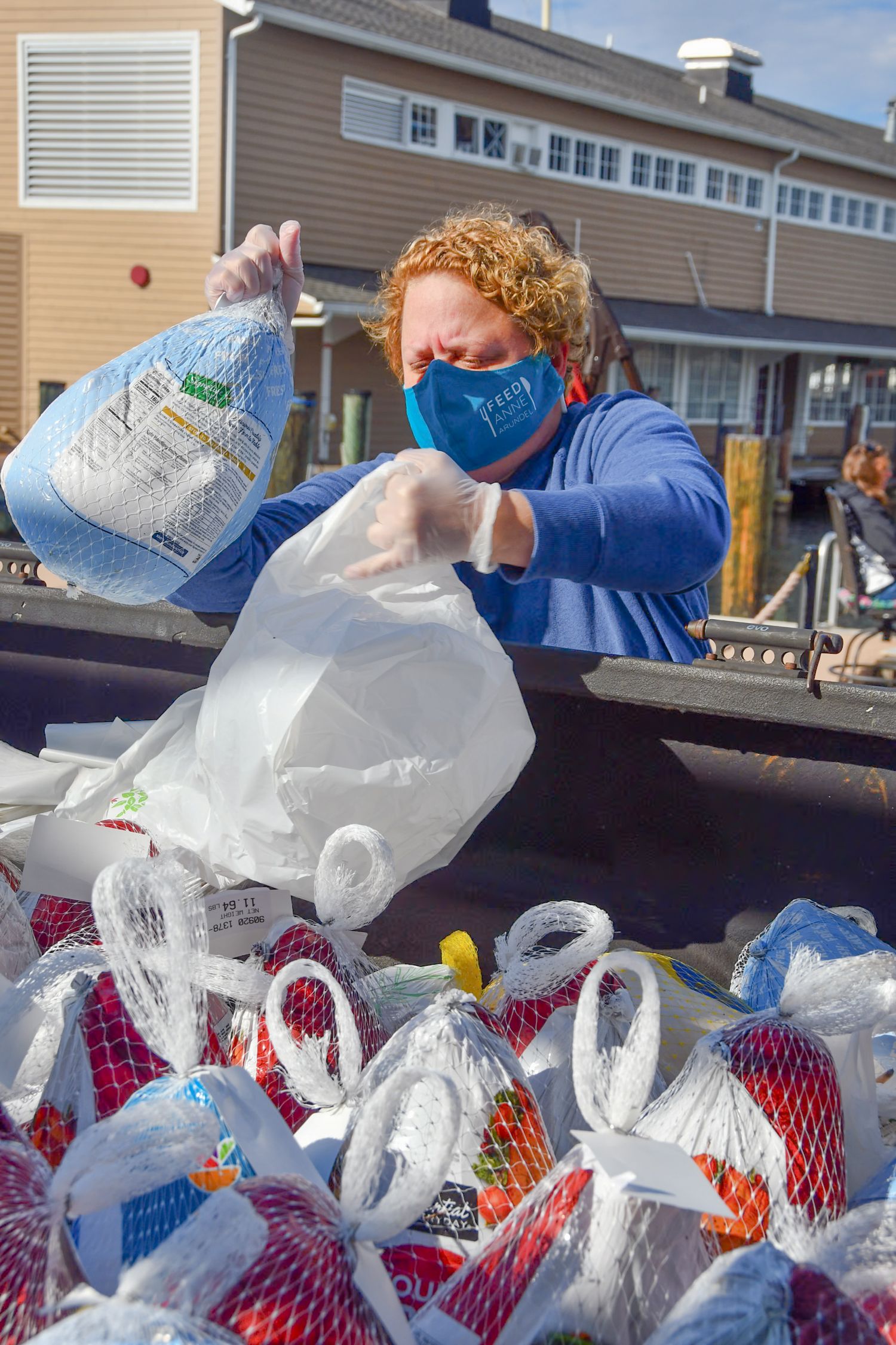 Stacks of bagged food items being loaded into vehicles at a distribution event.