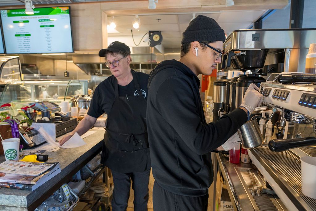 Staff working behind a counter in a food service establishment.